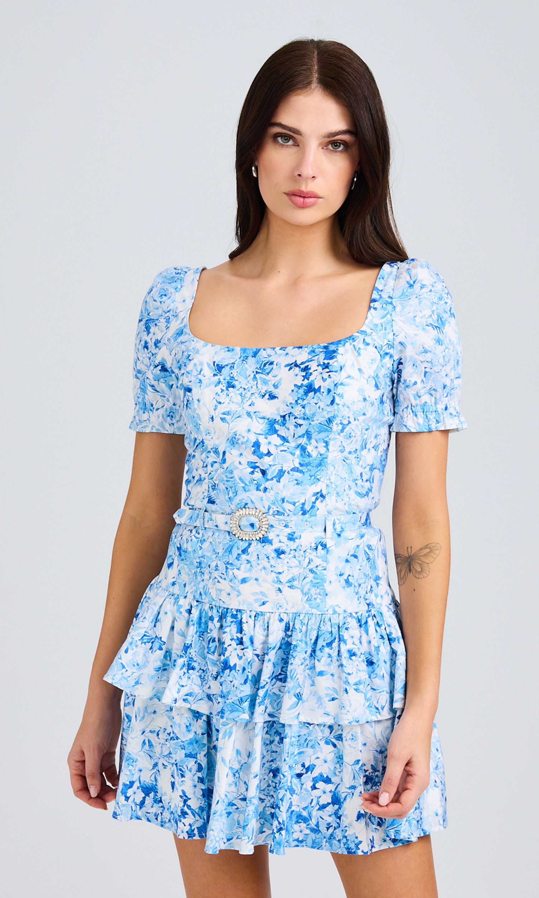 Front view of model wearing a blue floral mini dress with puff sleeves
