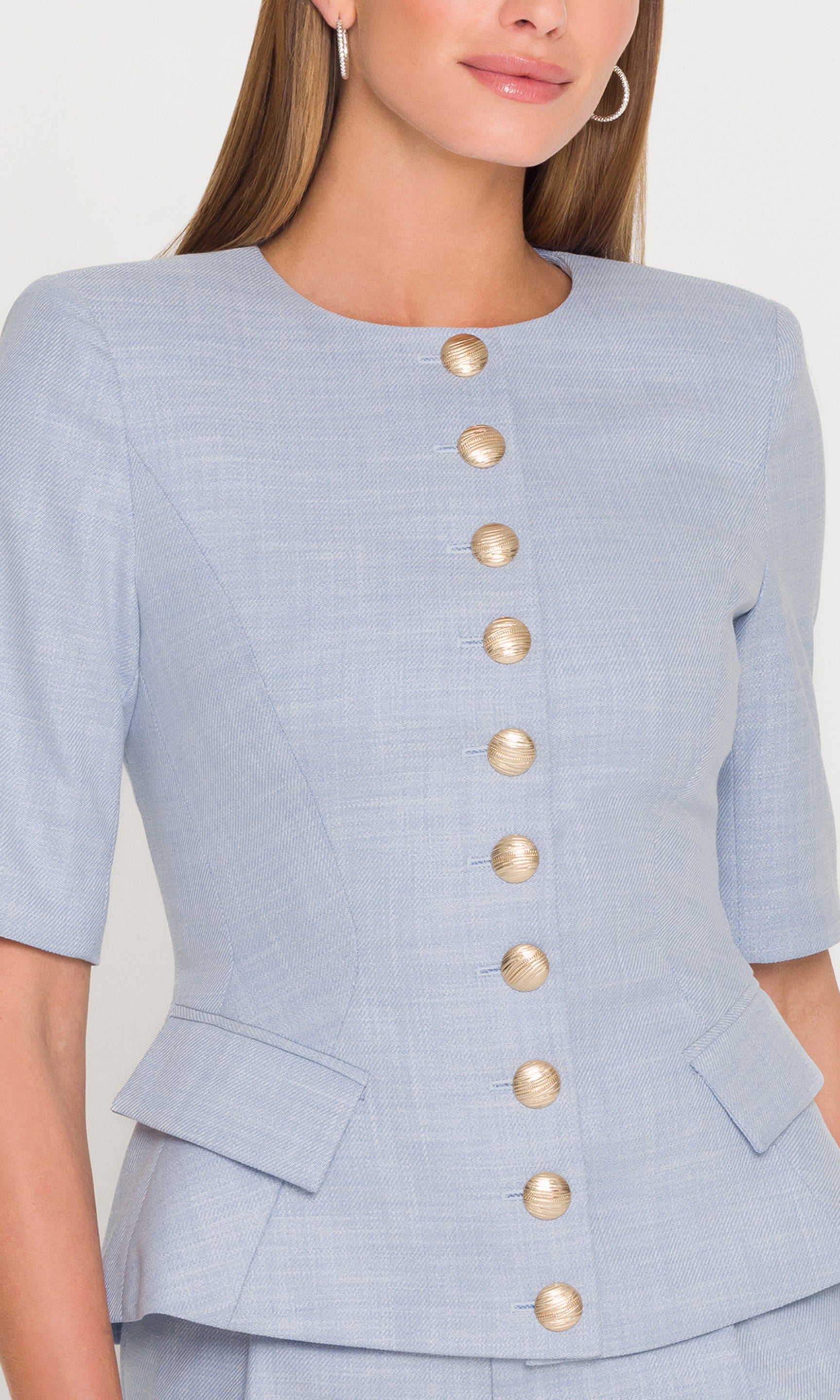 Model wears the Adriana Chambray Suiting Jacket in chambray blue in a cropped front view, highlighting the structured bodice and button-front detail.