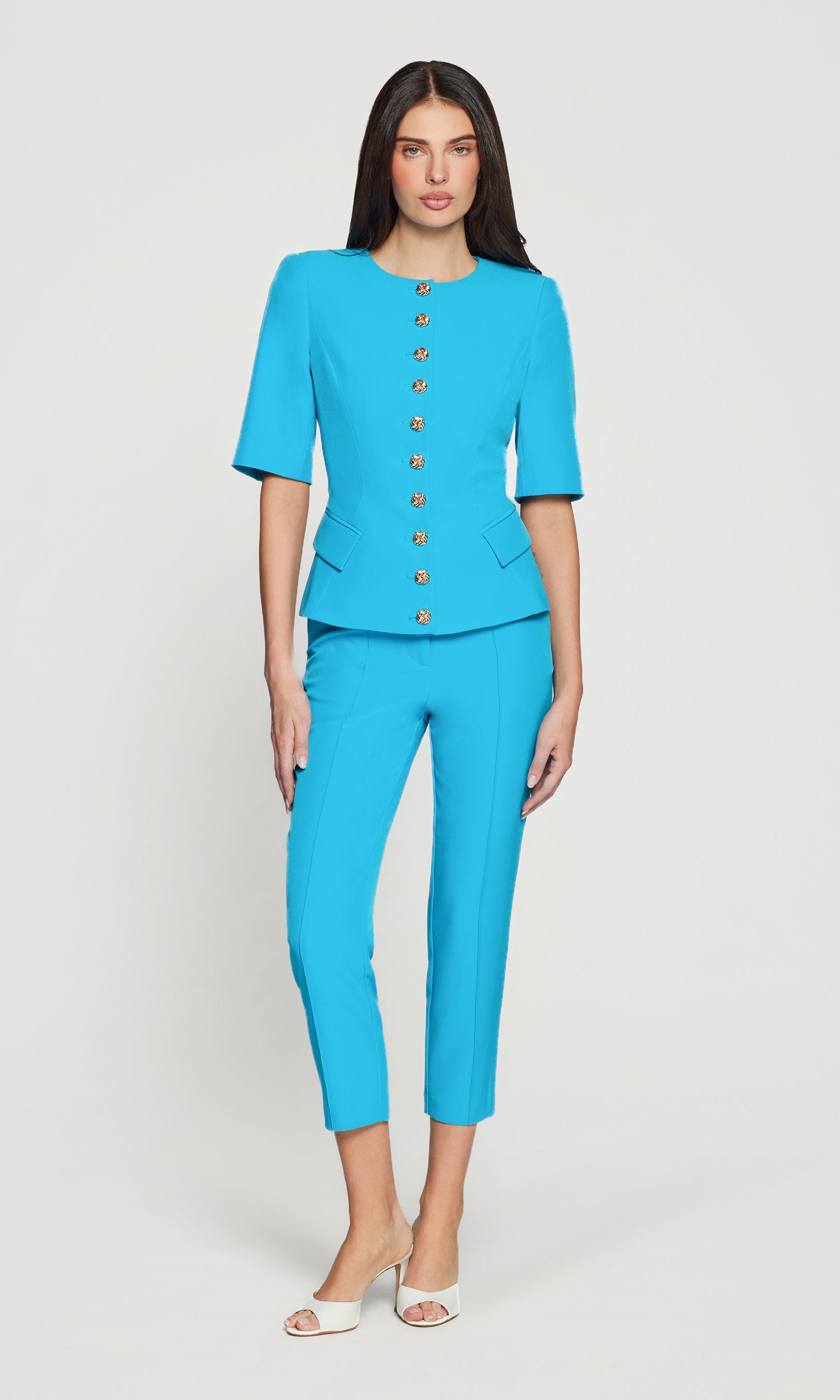 Woman wearing a bright blue suit with a white background