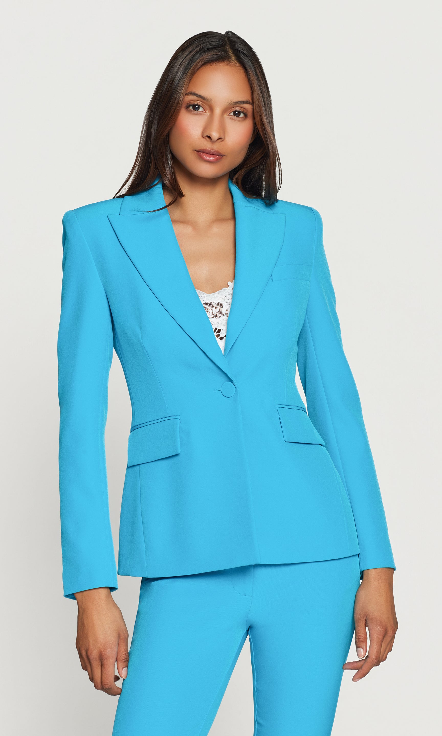 Woman wearing a bright blue suit against a white background