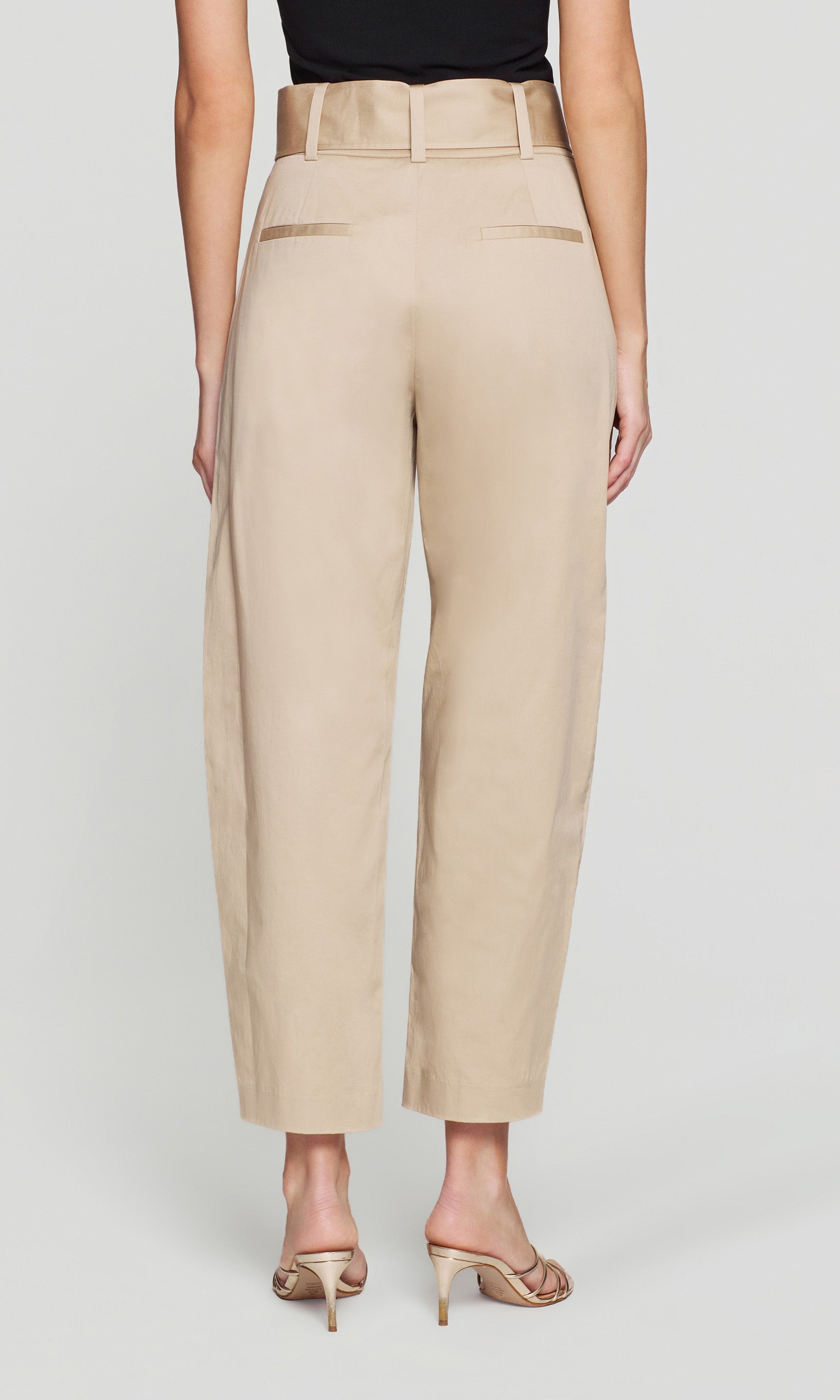Model wears the Cassie Cotton Sateen Pants in light khaki in a front view (legs-only), showing the full pant length and hem.