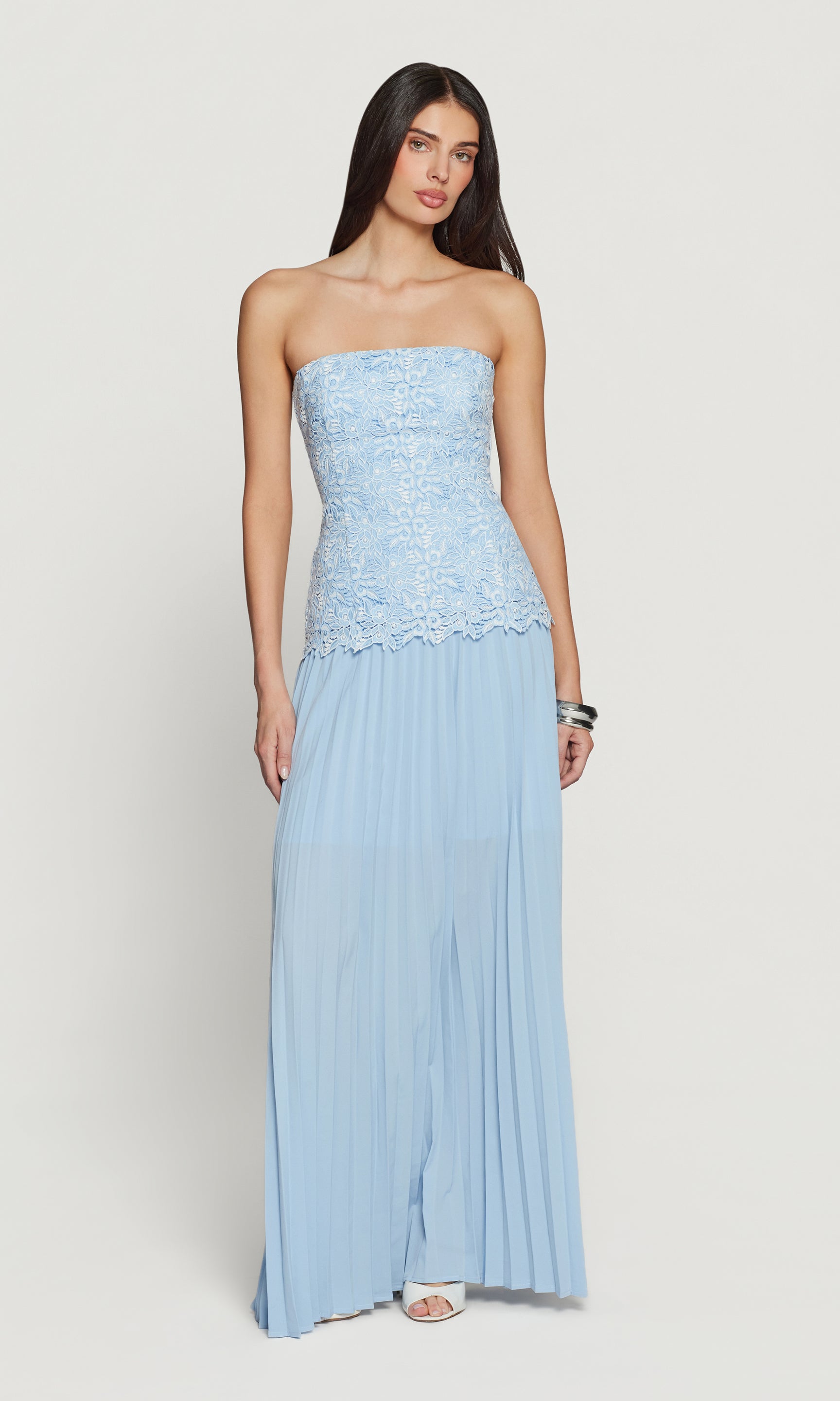 Woman wearing a light blue strapless gown on a white background