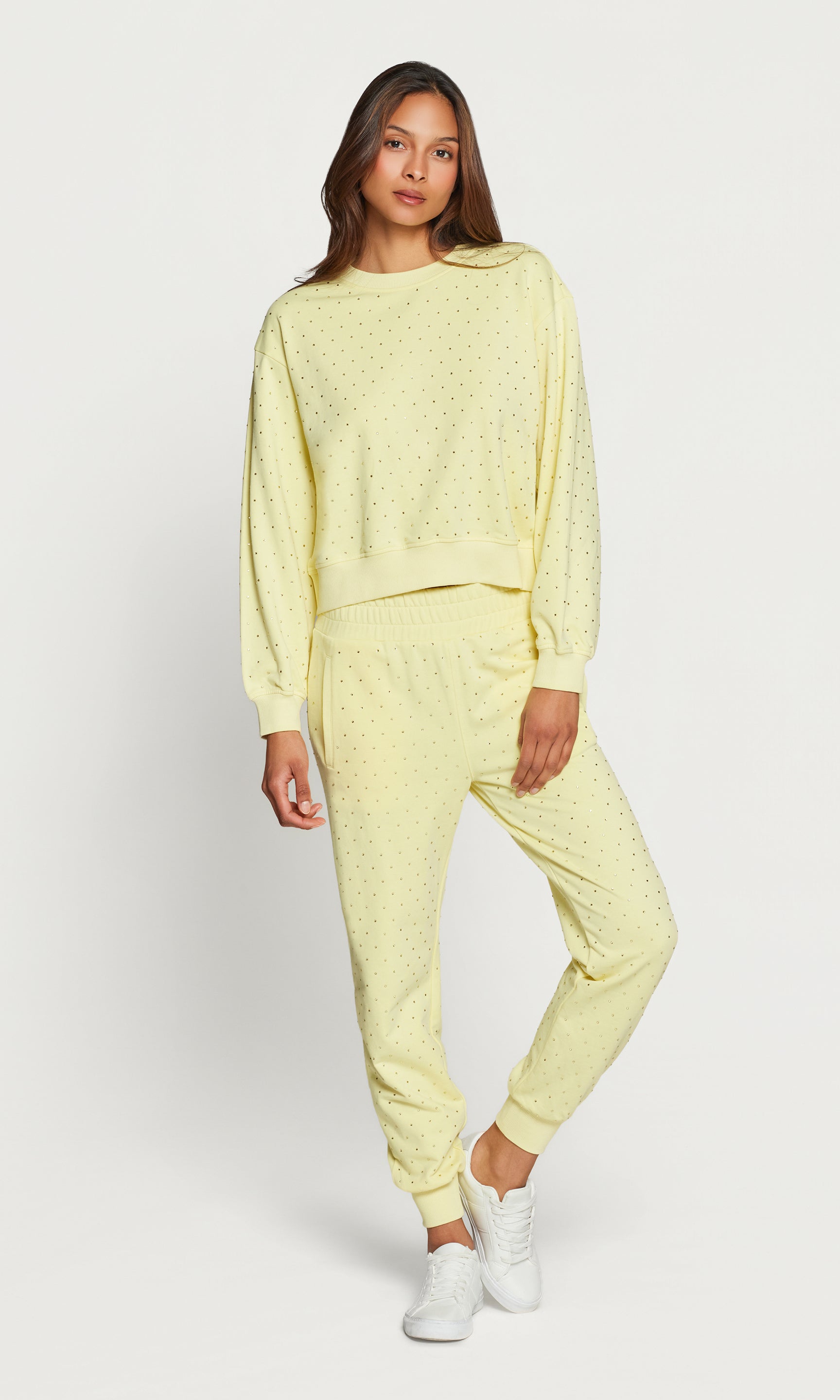 Woman wearing a light yellow loungewear set on a white background