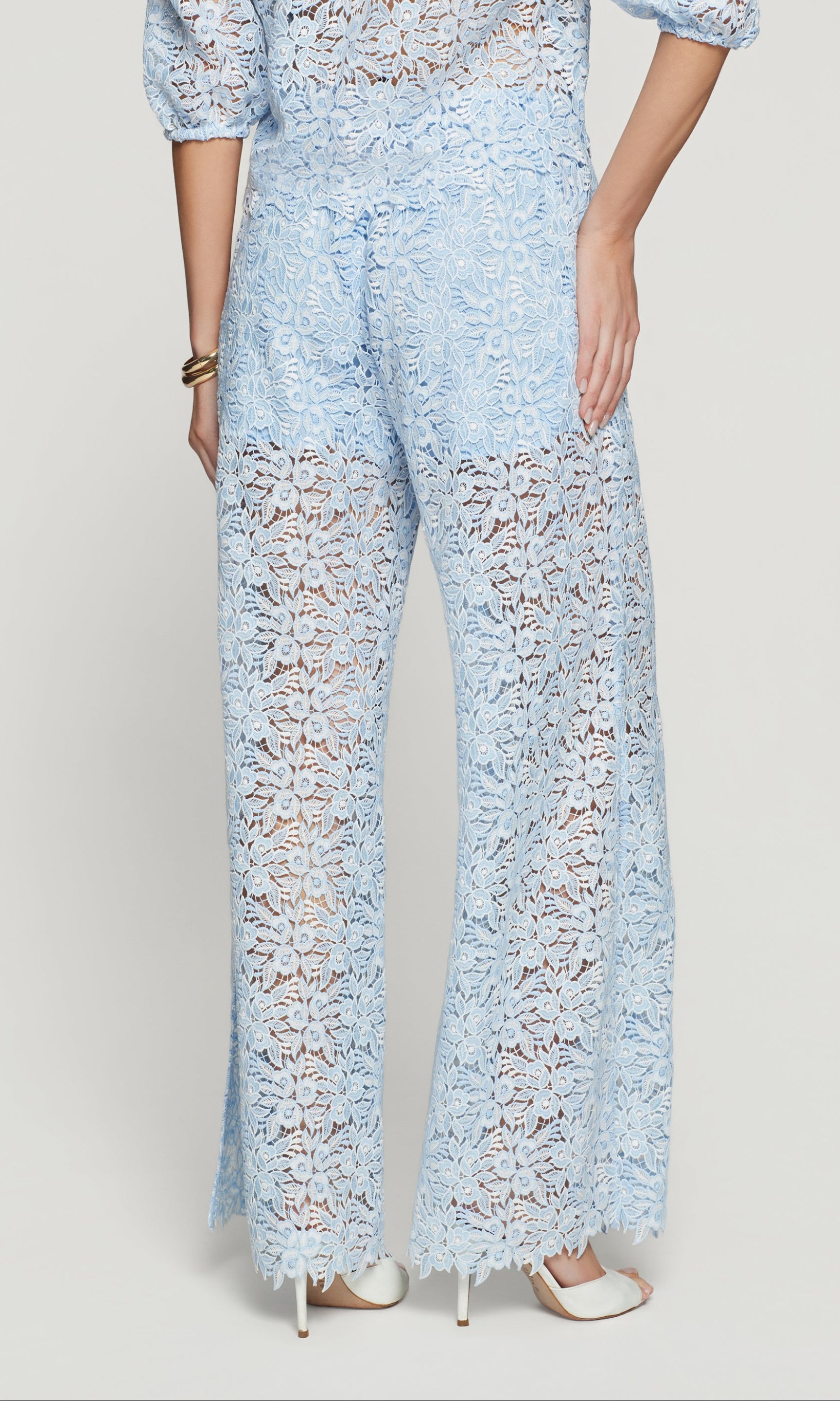 Back view of light blue lace pants worn by a person on a white background