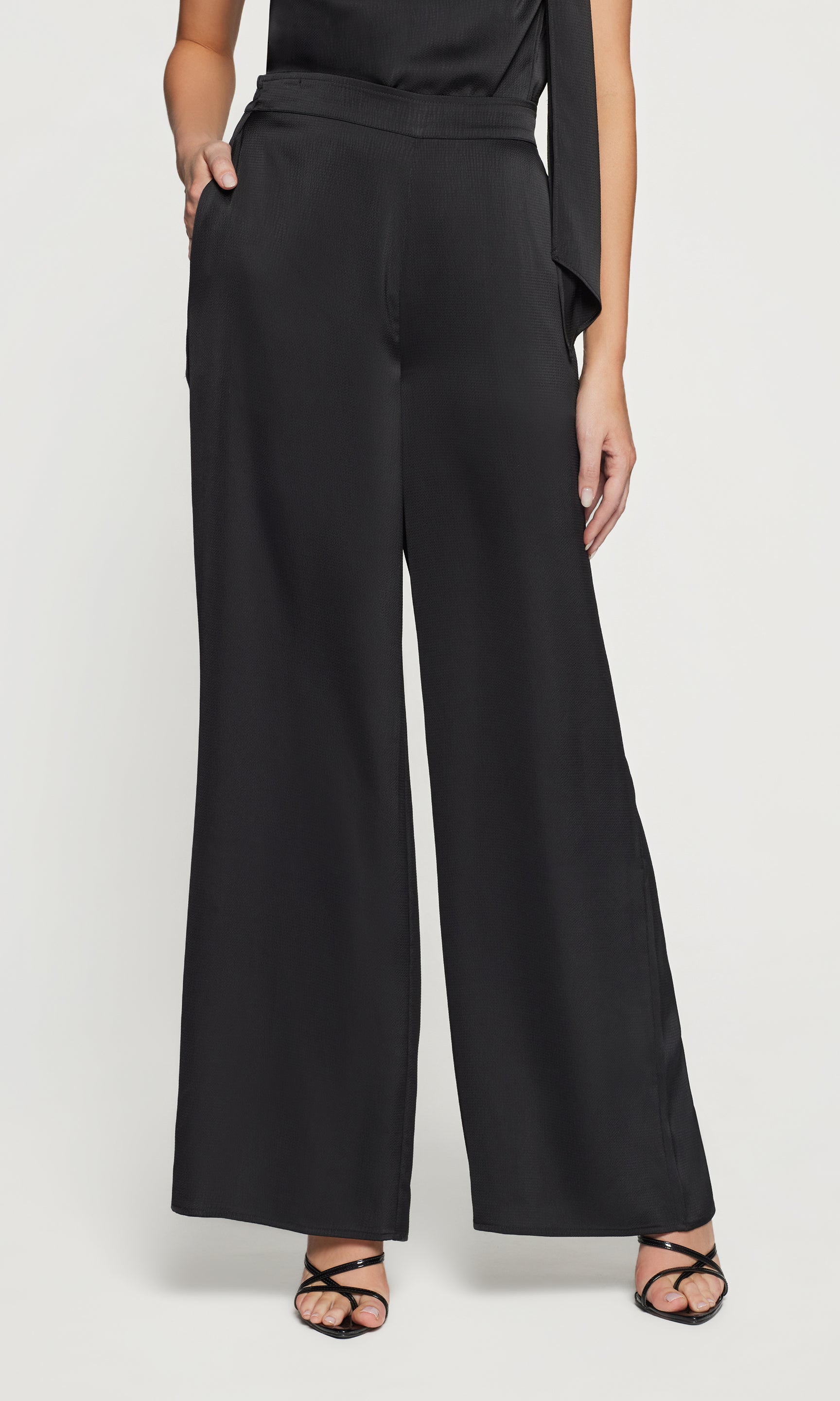 Black wide-leg pants worn by a person on a white background