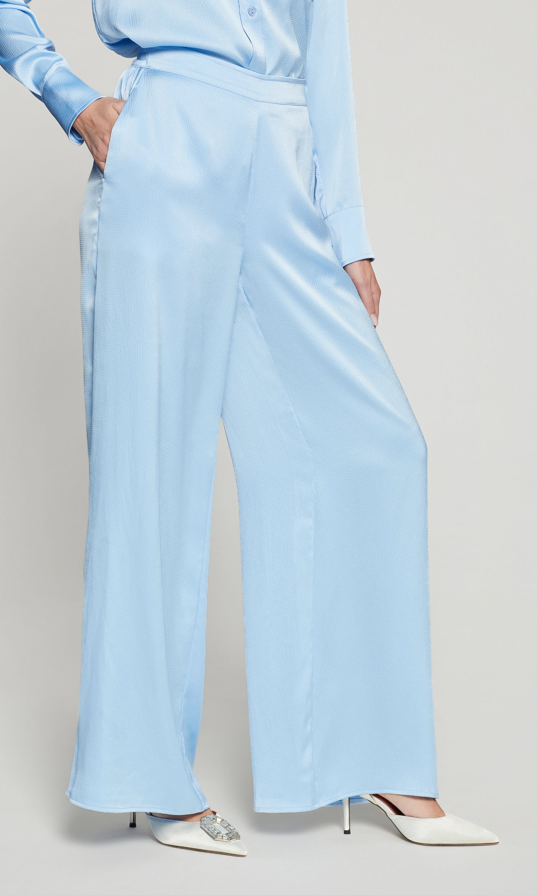 Sie view of light blue outfit with wide-leg pants and a matching top on a plain background