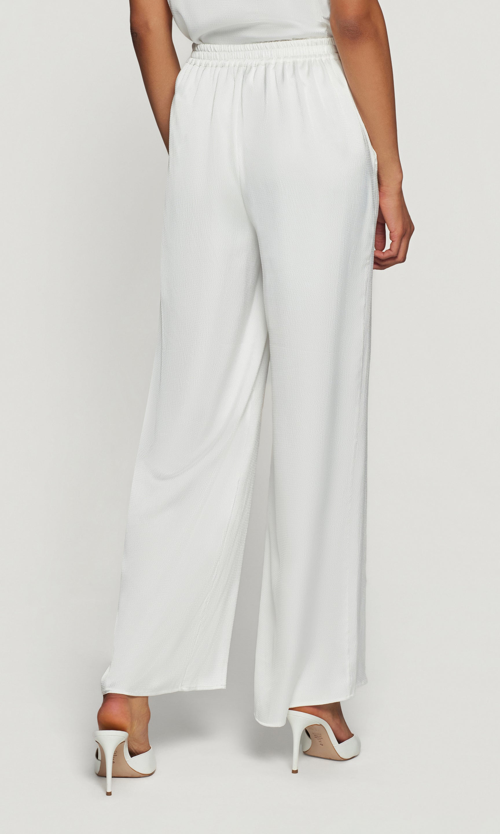 White wide-leg pants worn by a person on a white background