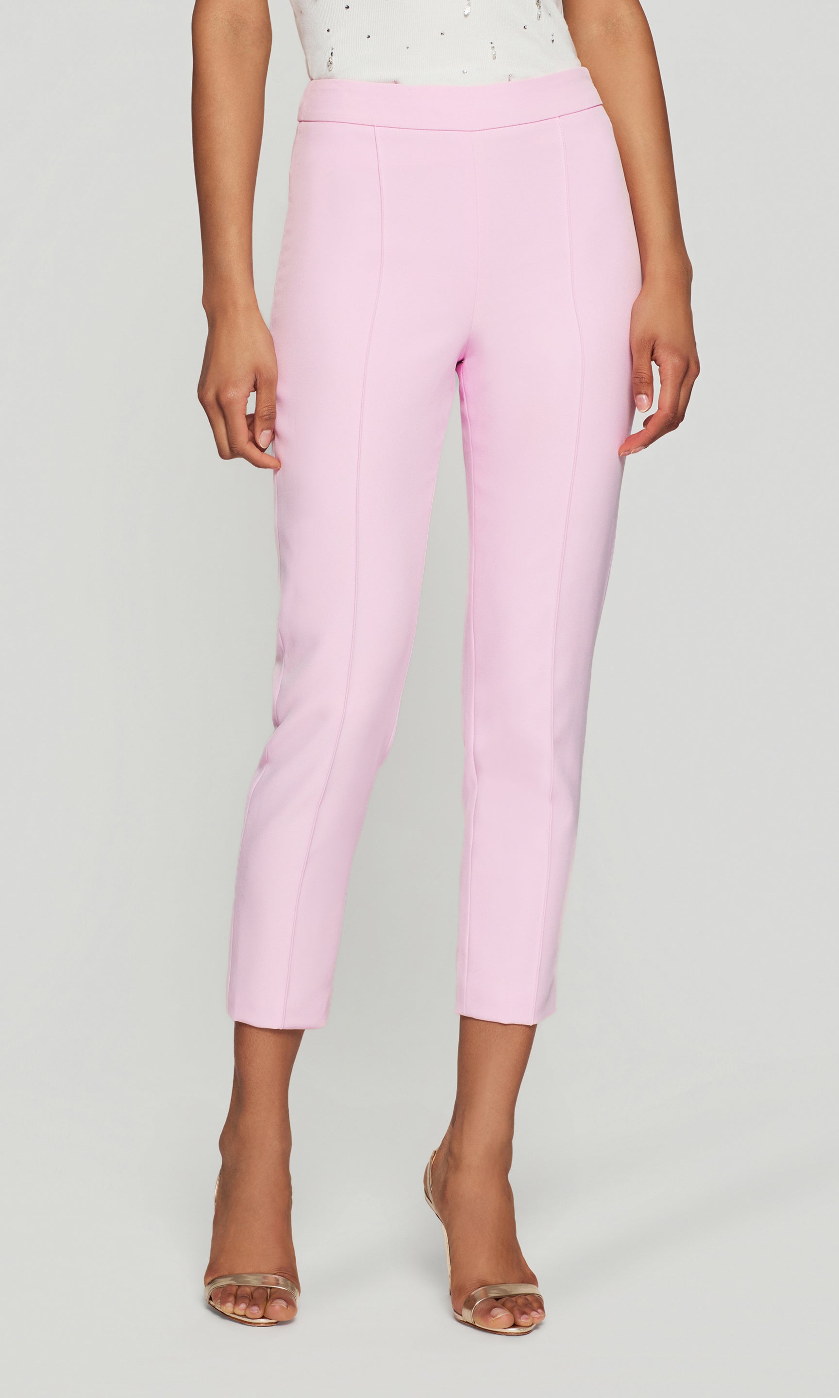 Front view of the model wearing the Lonny Crepe Pants in soft rose on a neutral background, focused on the full length to show the crisp leg line and refined ankle hem.