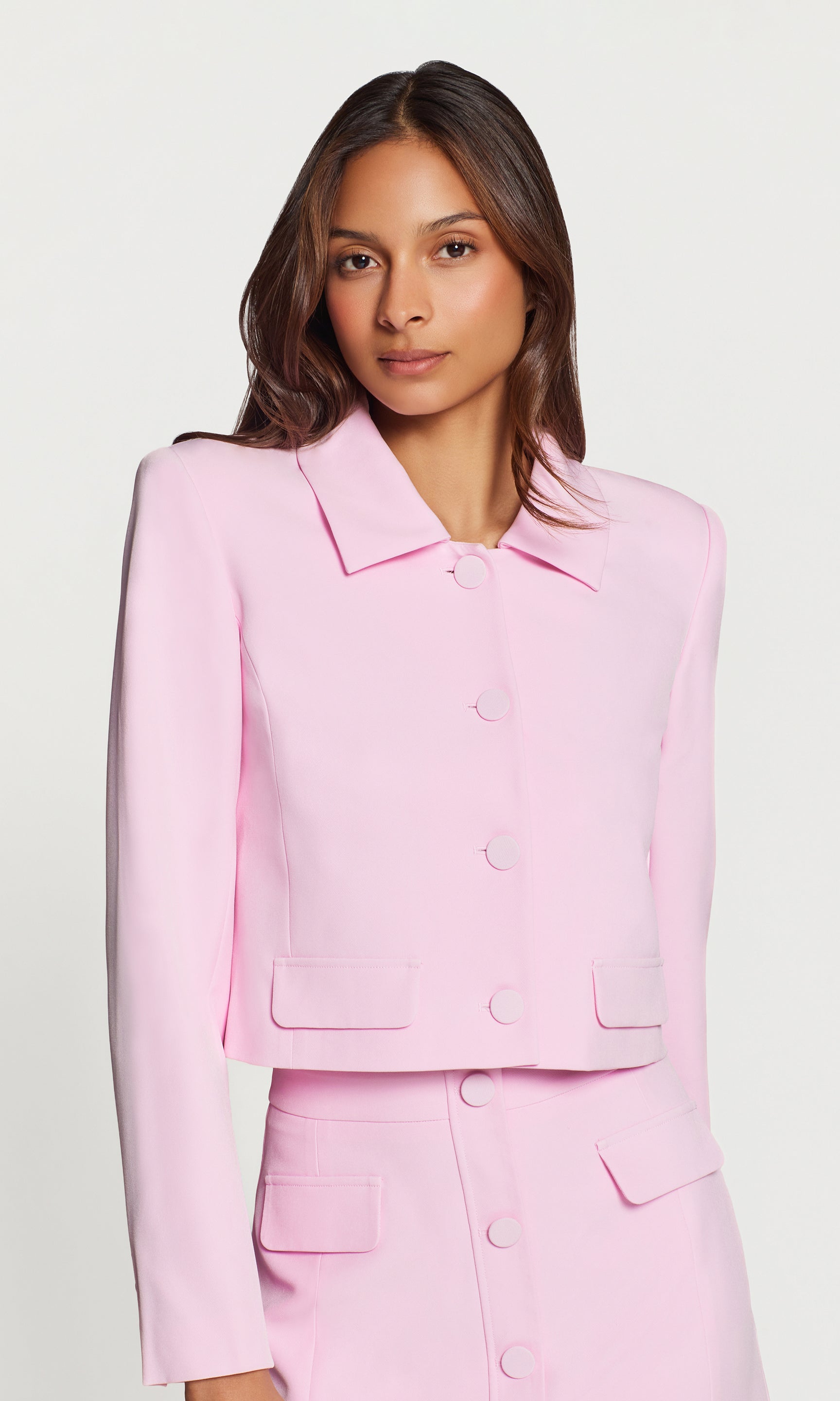 Woman wearing a pink suit on a white background