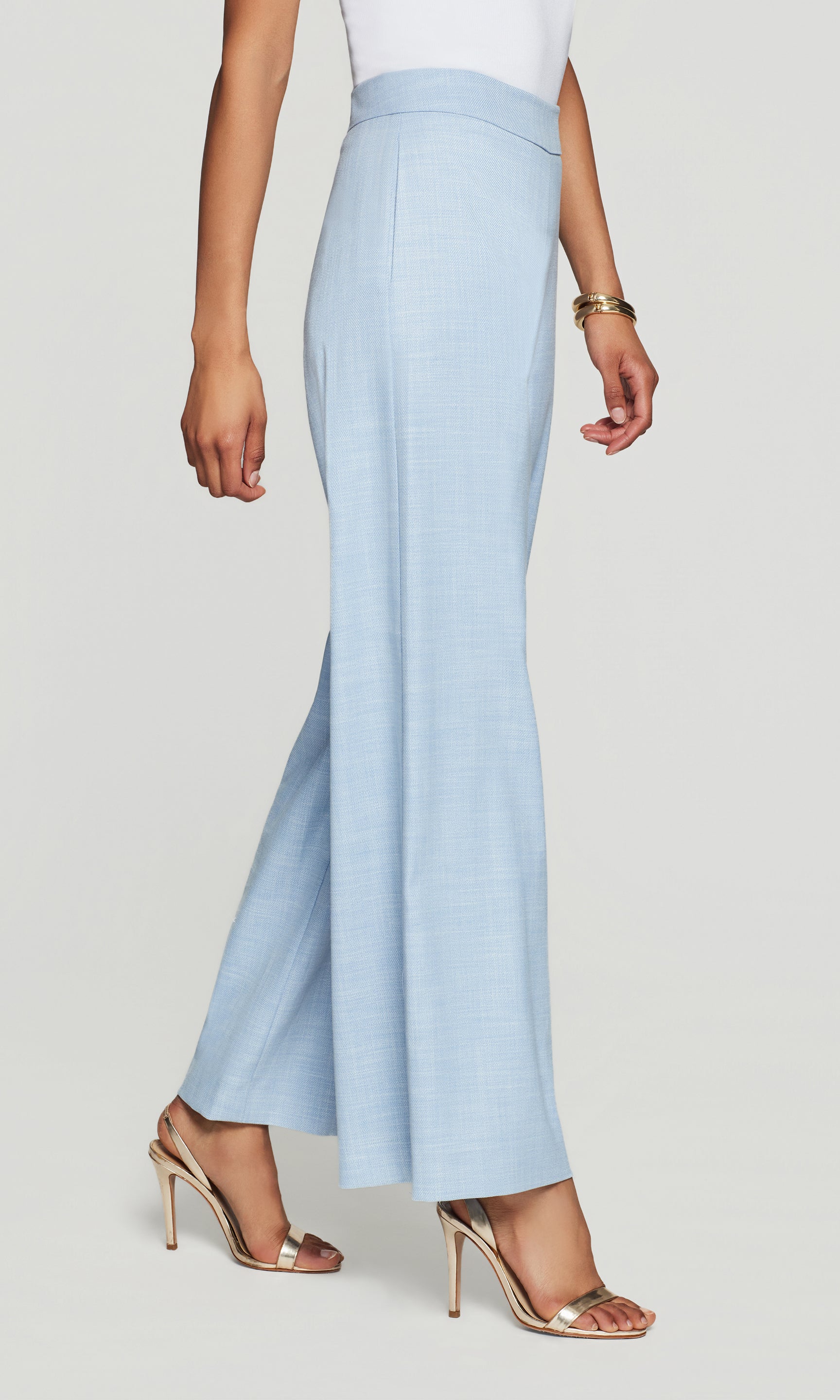 Magda Chambray Suiting Pants in chambray blue shown on the model in a side view crop from waist to hem with heels.