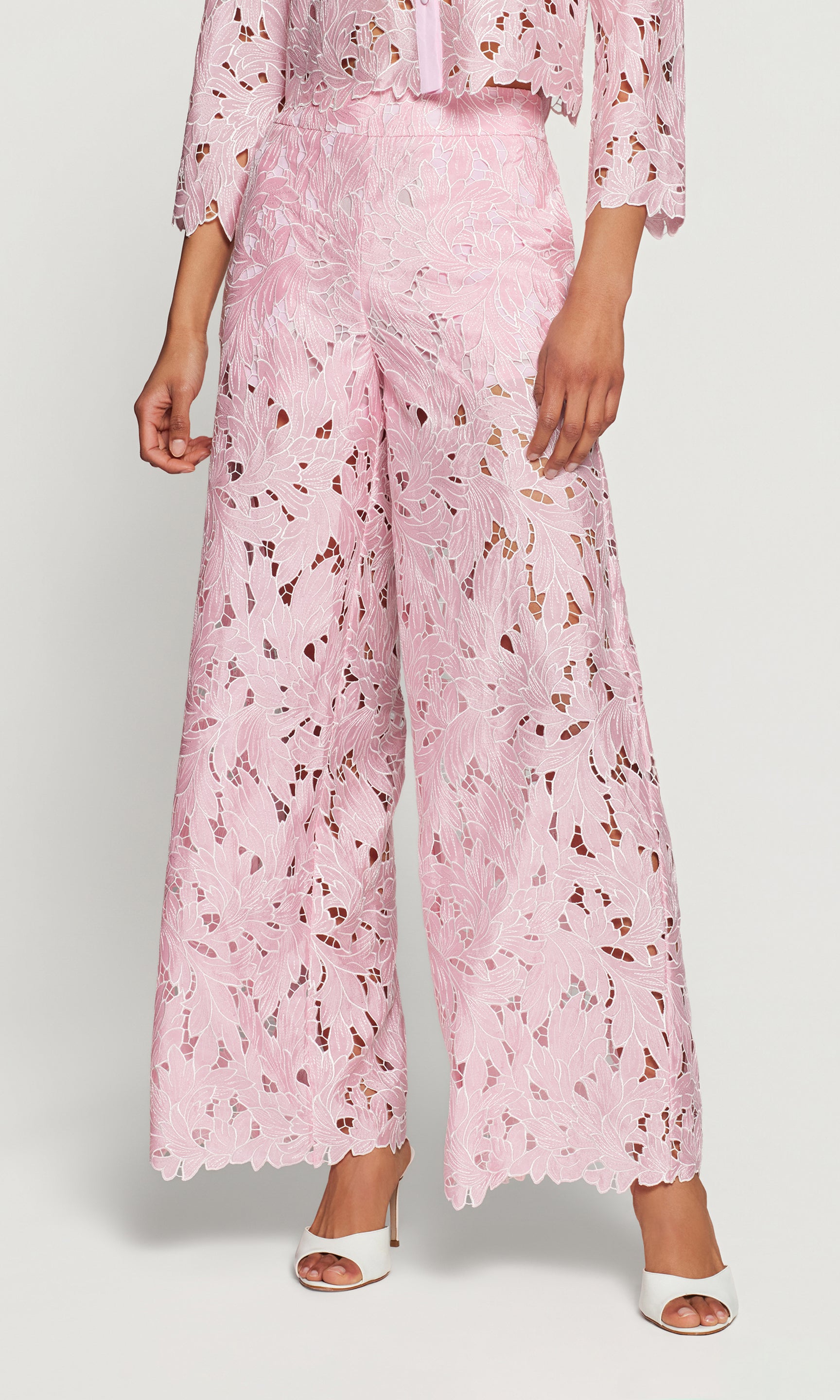 Person wearing pink floral pants on a white background