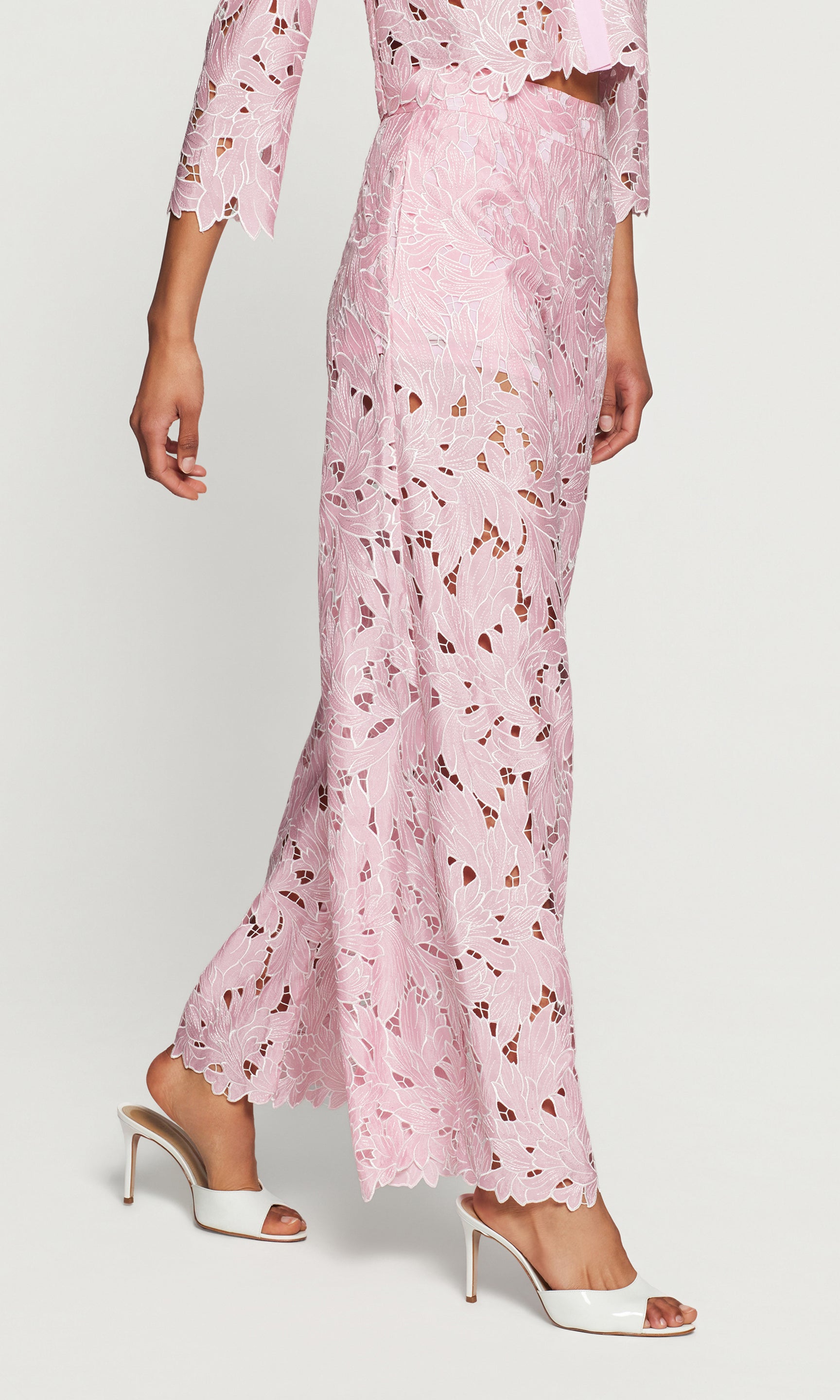 Side view of person wearing pink floral pants on a white background