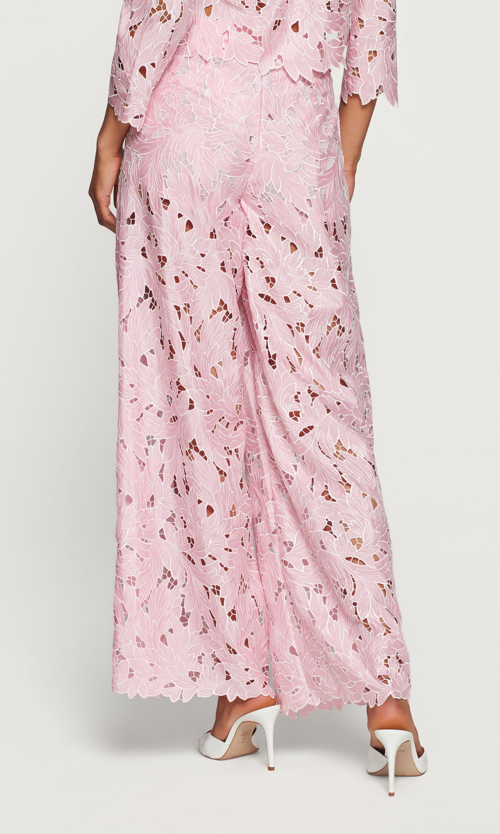 Back view of person wearing pink floral pants on a white background