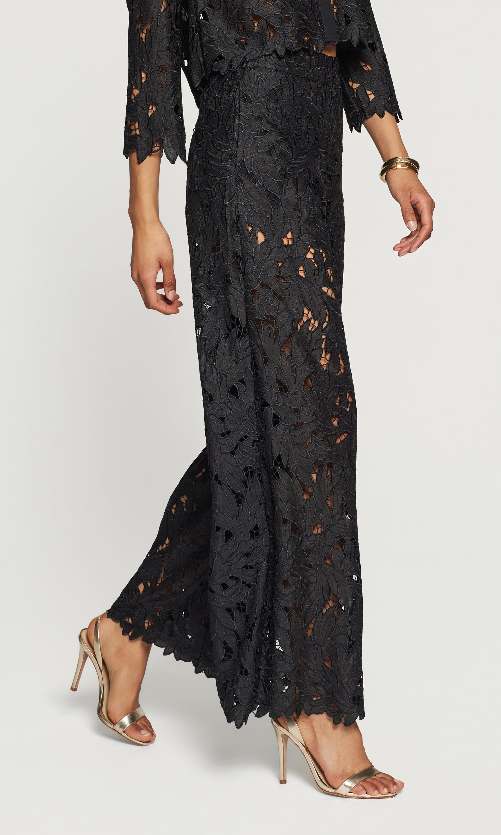 Side view of black lace outfit with high-waisted pants and a top on a white background