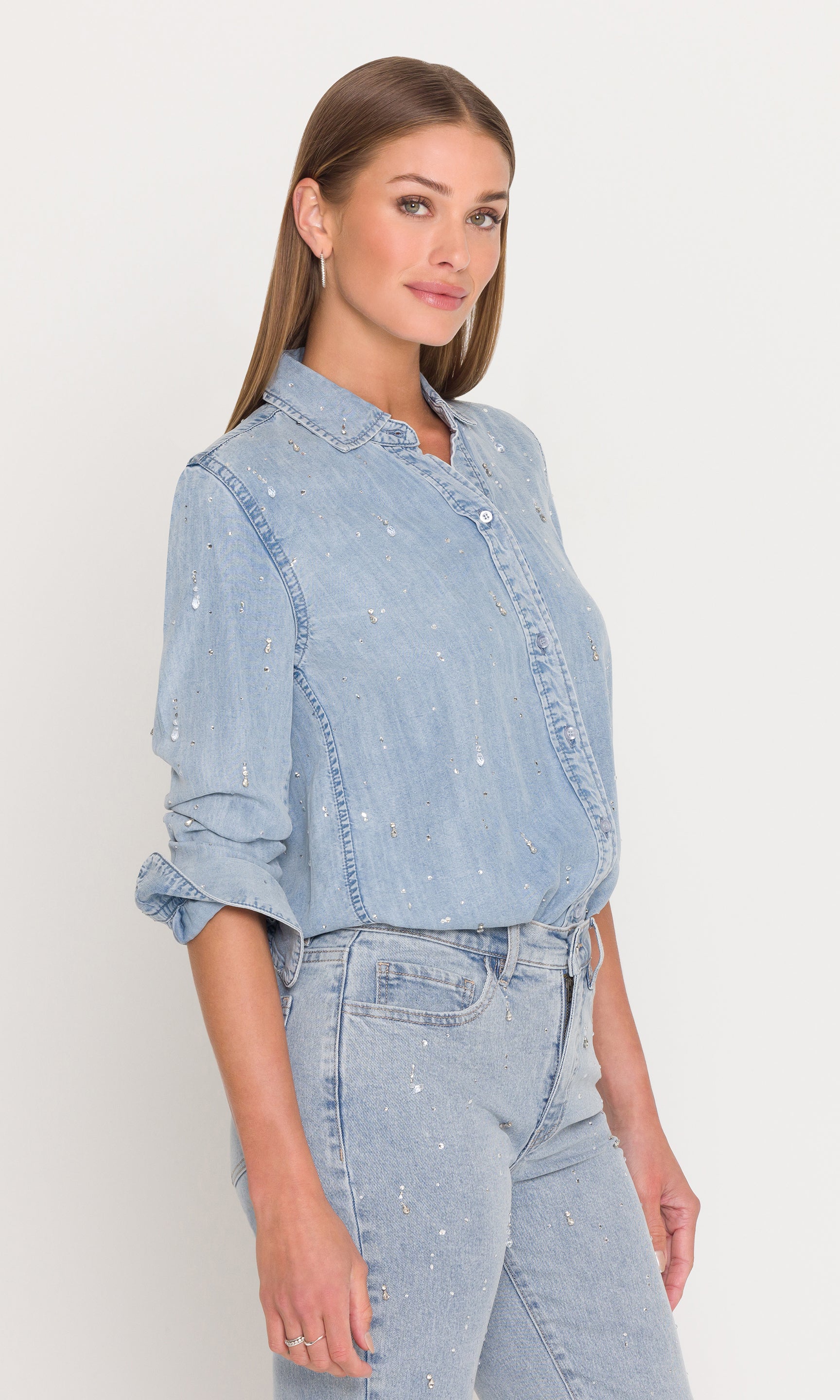 Side view of woman wearing a light blue denim outfit on a white background
