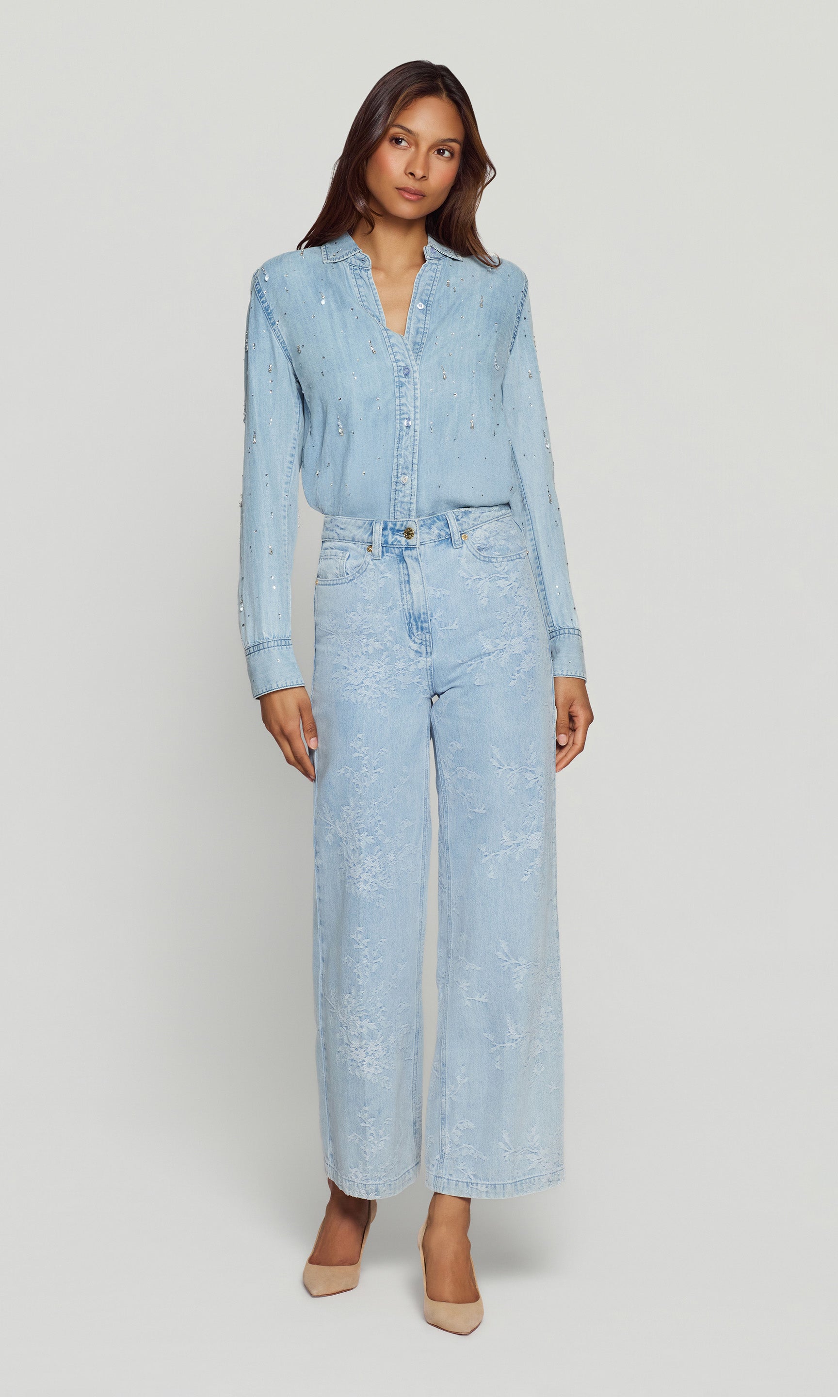 Woman wearing a light blue denim outfit on a white background