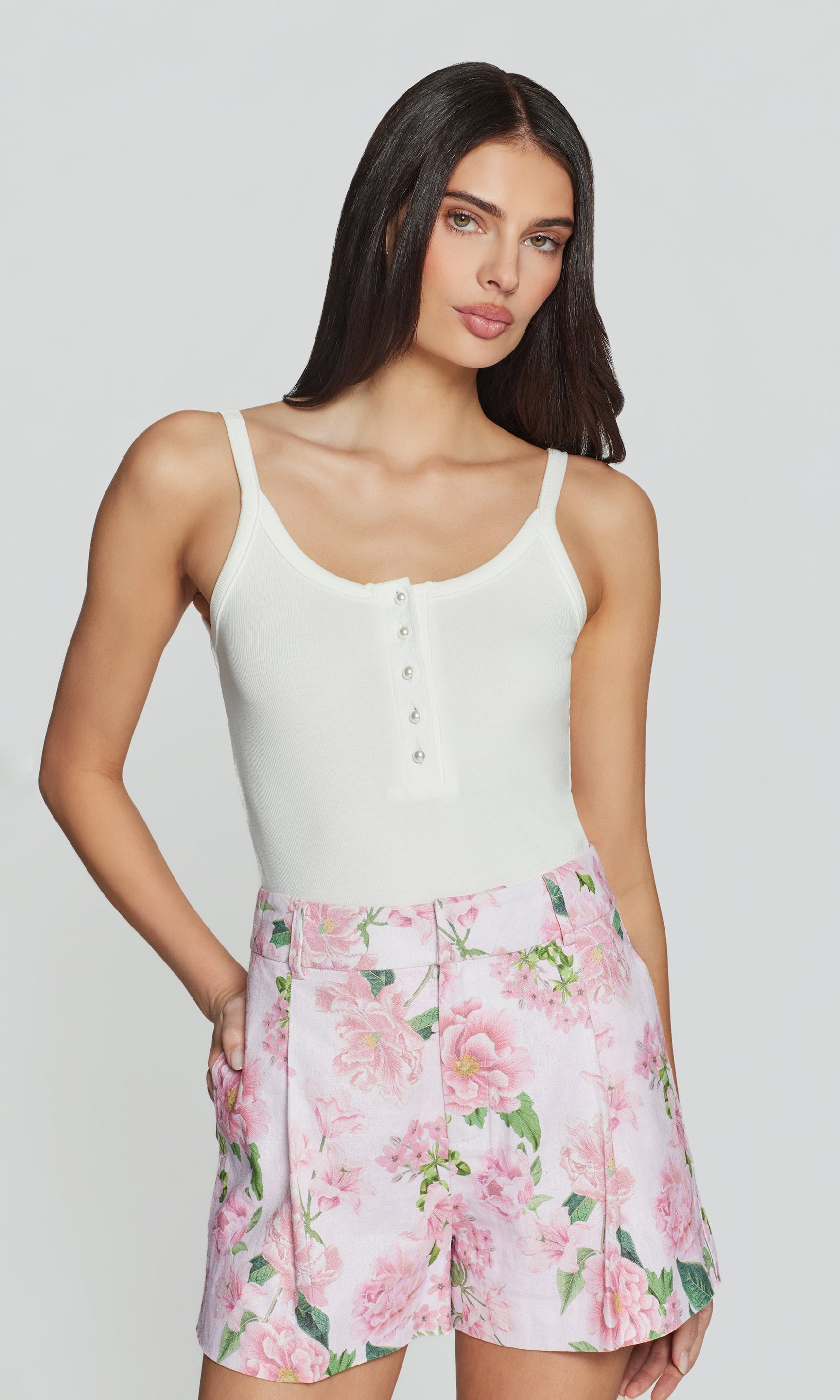 The model appears in a full body front view wearing the Molly Rib Tank Top in white with a floral mini skirt, showcasing a fresh, feminine outfit.