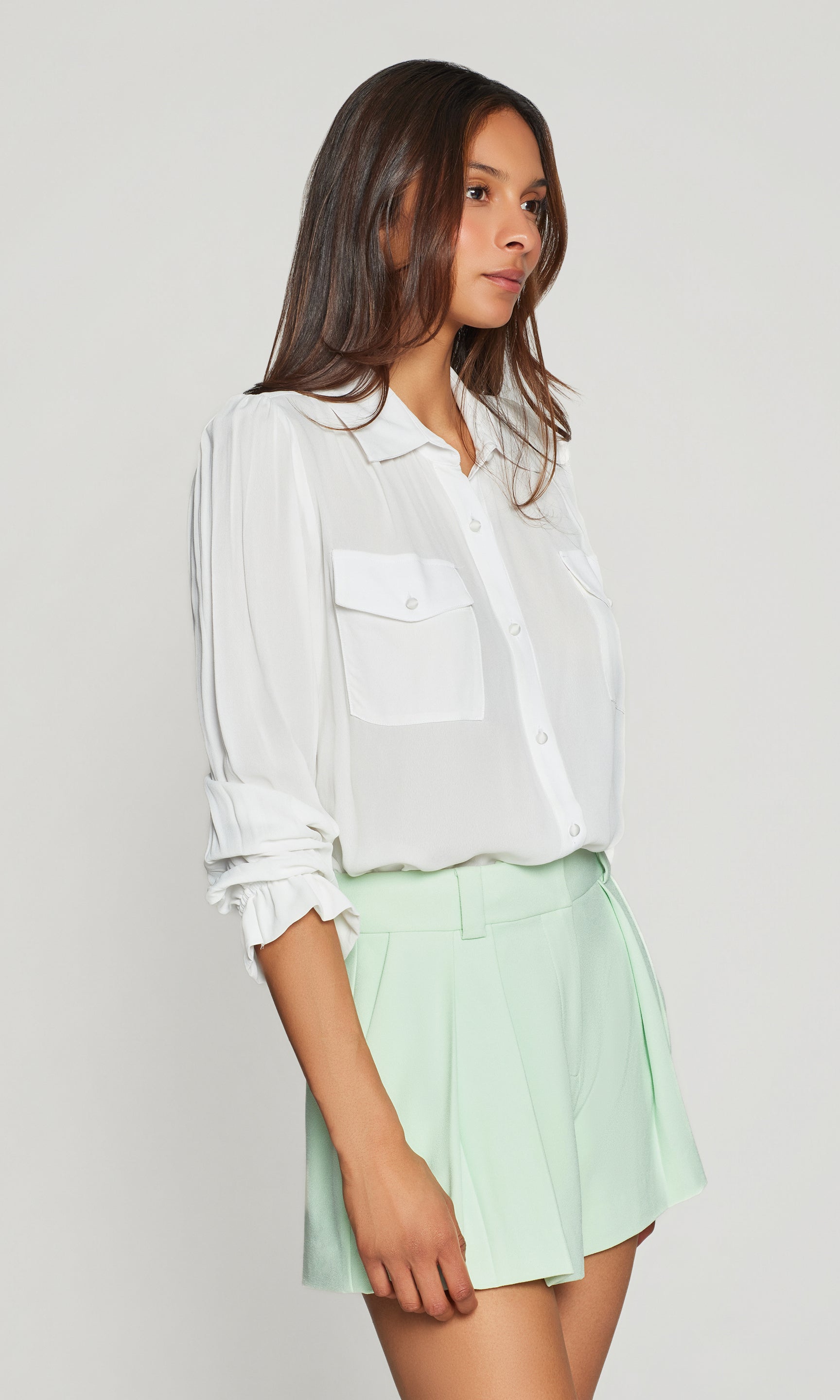 Model wears the Priya Georgette Shirt in white in a side view, capturing the loose, floaty shape and the clean cuff styling on the sleeves