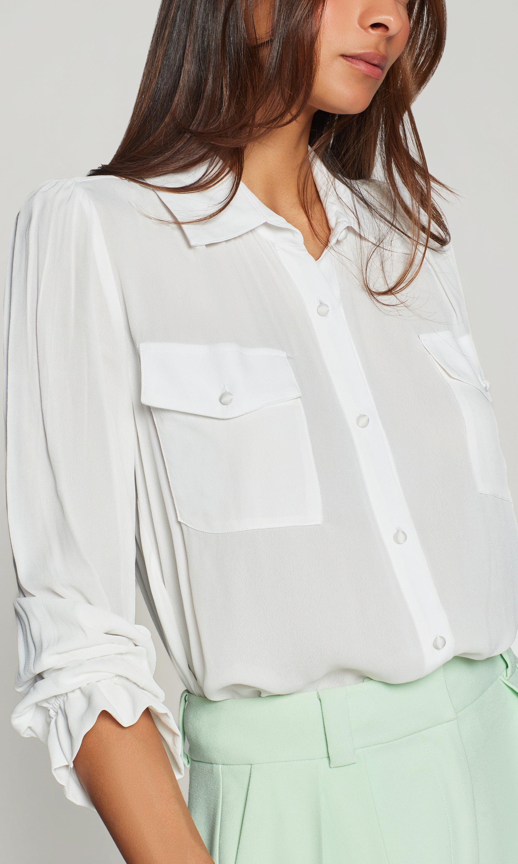 Model wears the Priya Georgette Shirt in white in a close-up view, focusing on the soft collar, button placket, and pocket flap details at the chest