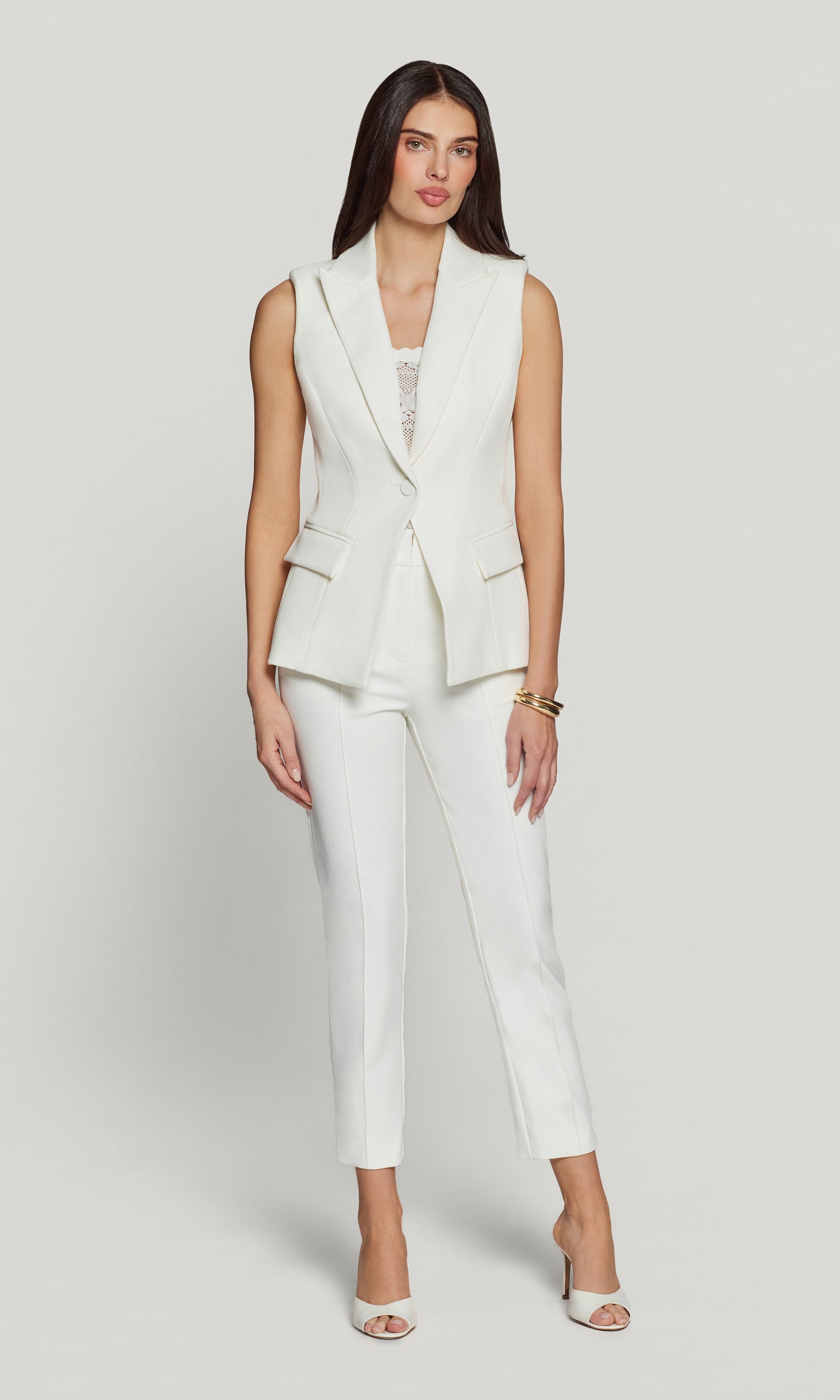 Woman wearing a white suit on a plain background