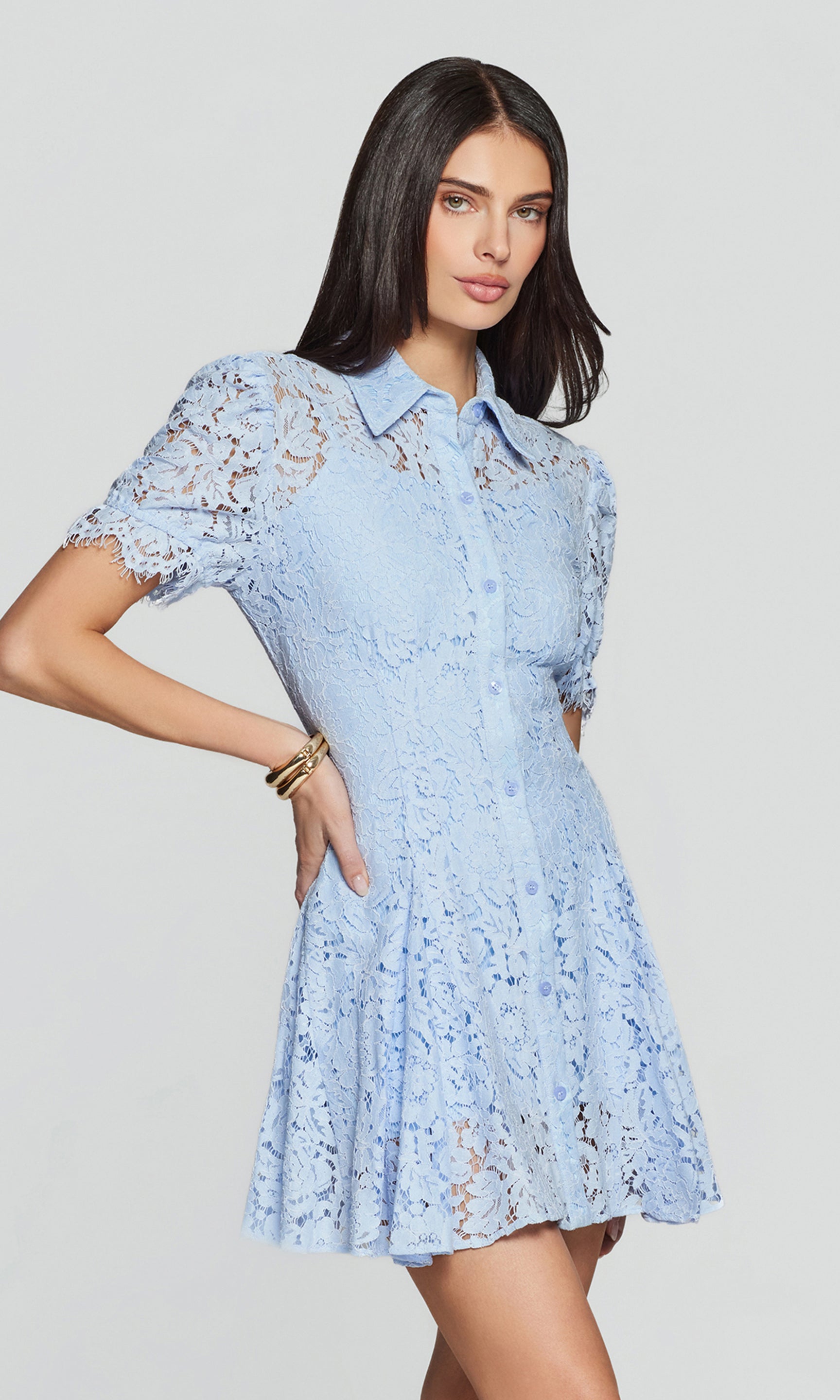 Side view of woman wearing a light blue lace dress on a gray background
