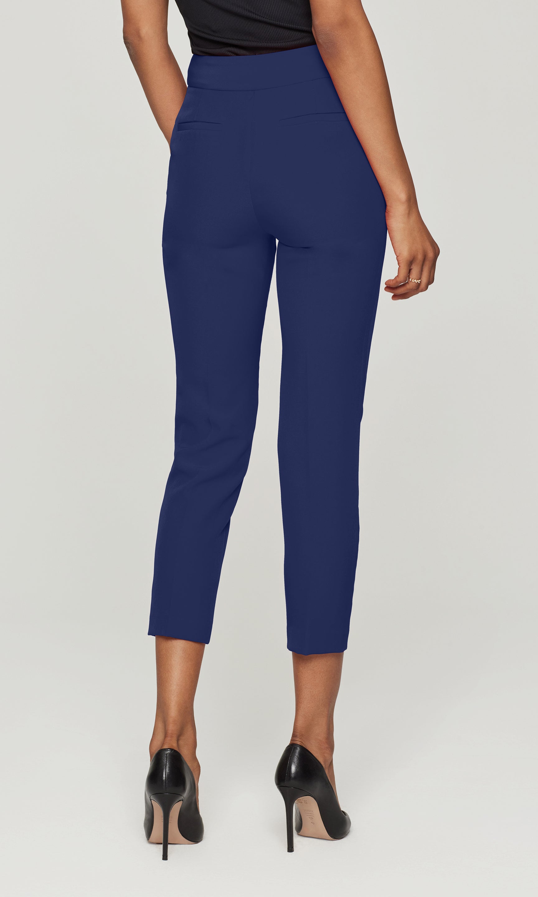 Back view of person wearing blue pants on a plain background