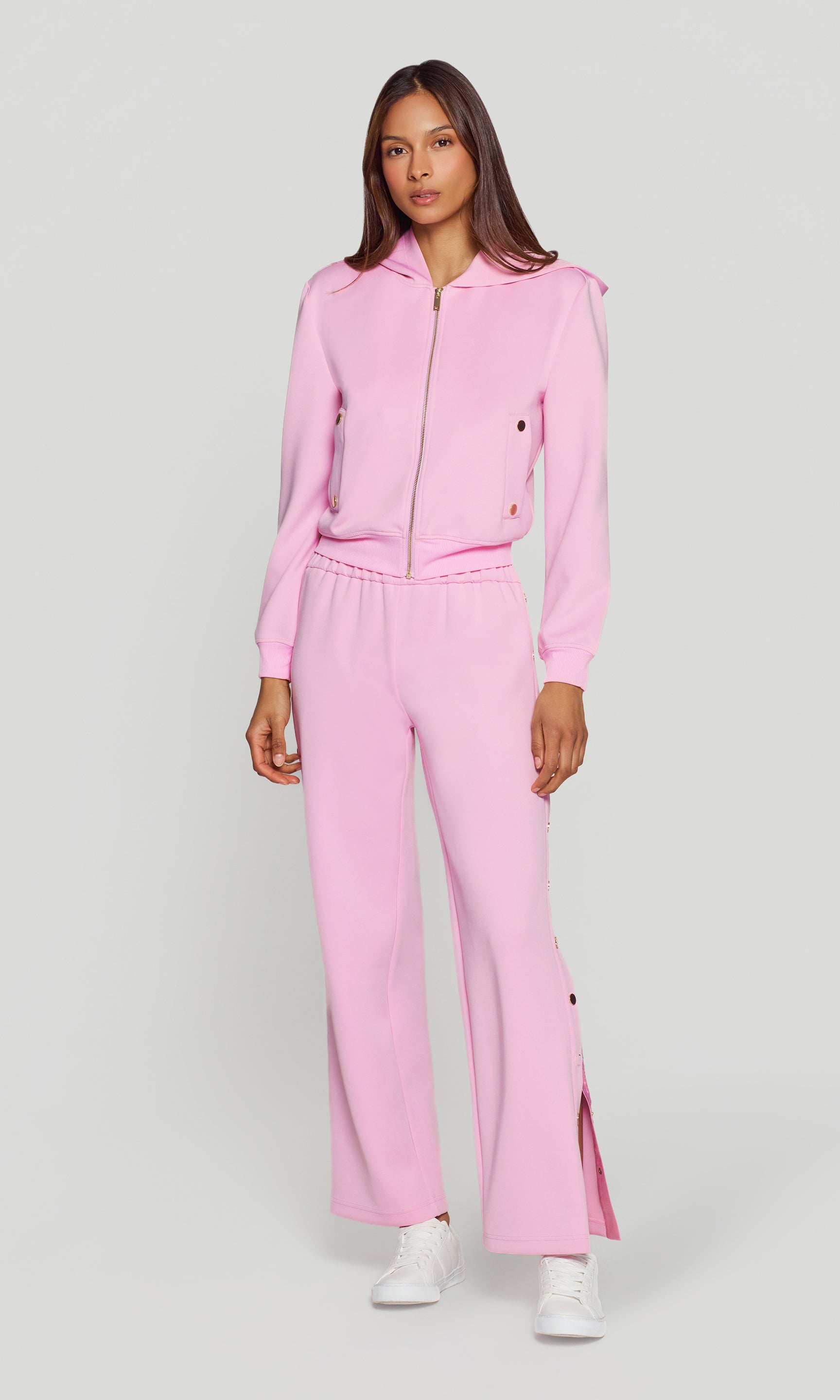 Woman wearing a pink tracksuit on a white background