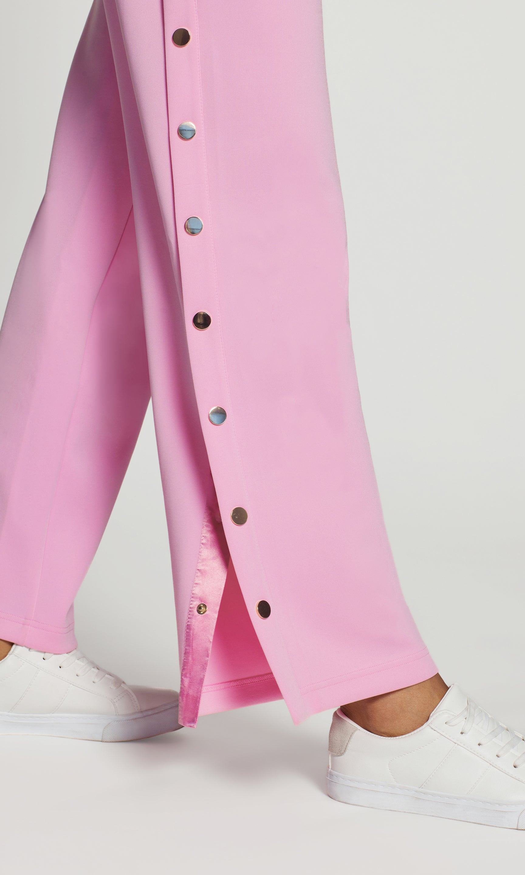 Close-up of pink button-up pants with a white background