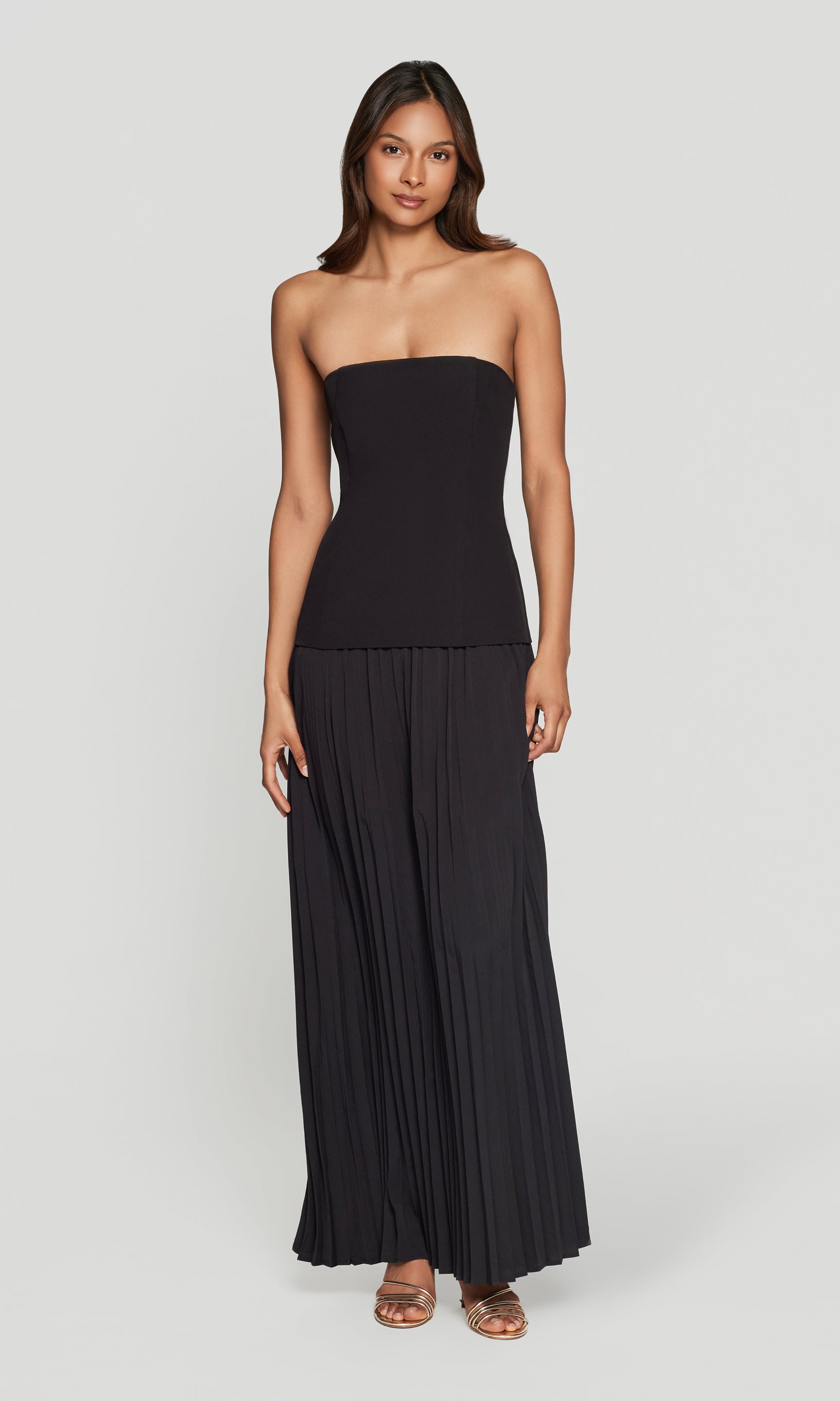 Woman wearing a black strapless gown on a white background