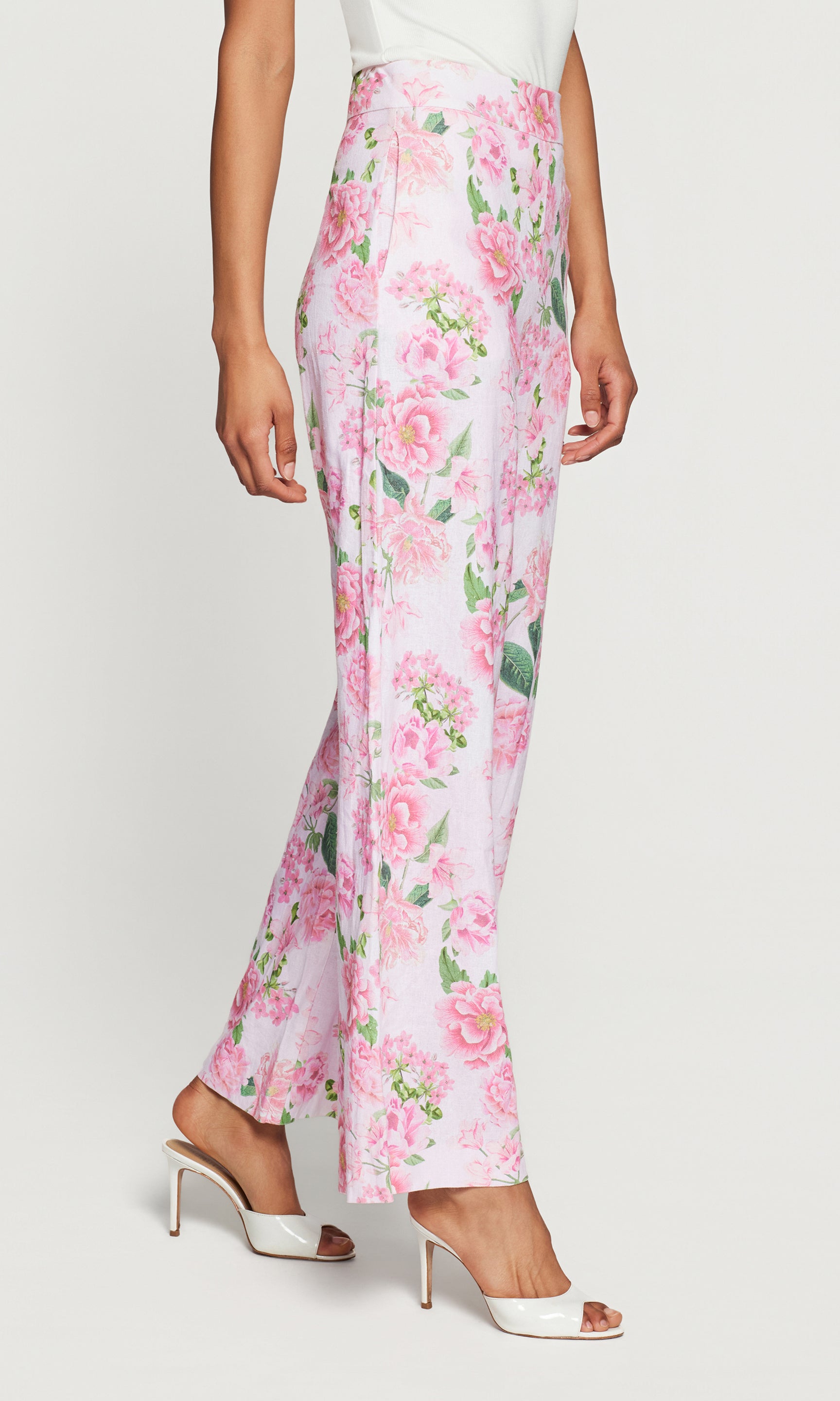 Side view of floral pants worn by a person on a white background