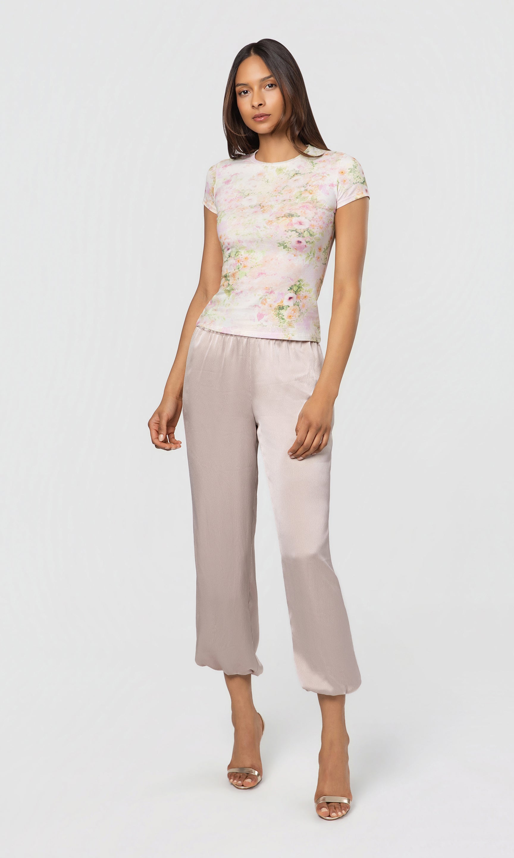 Woman wearing a white top and beige pants on a white background