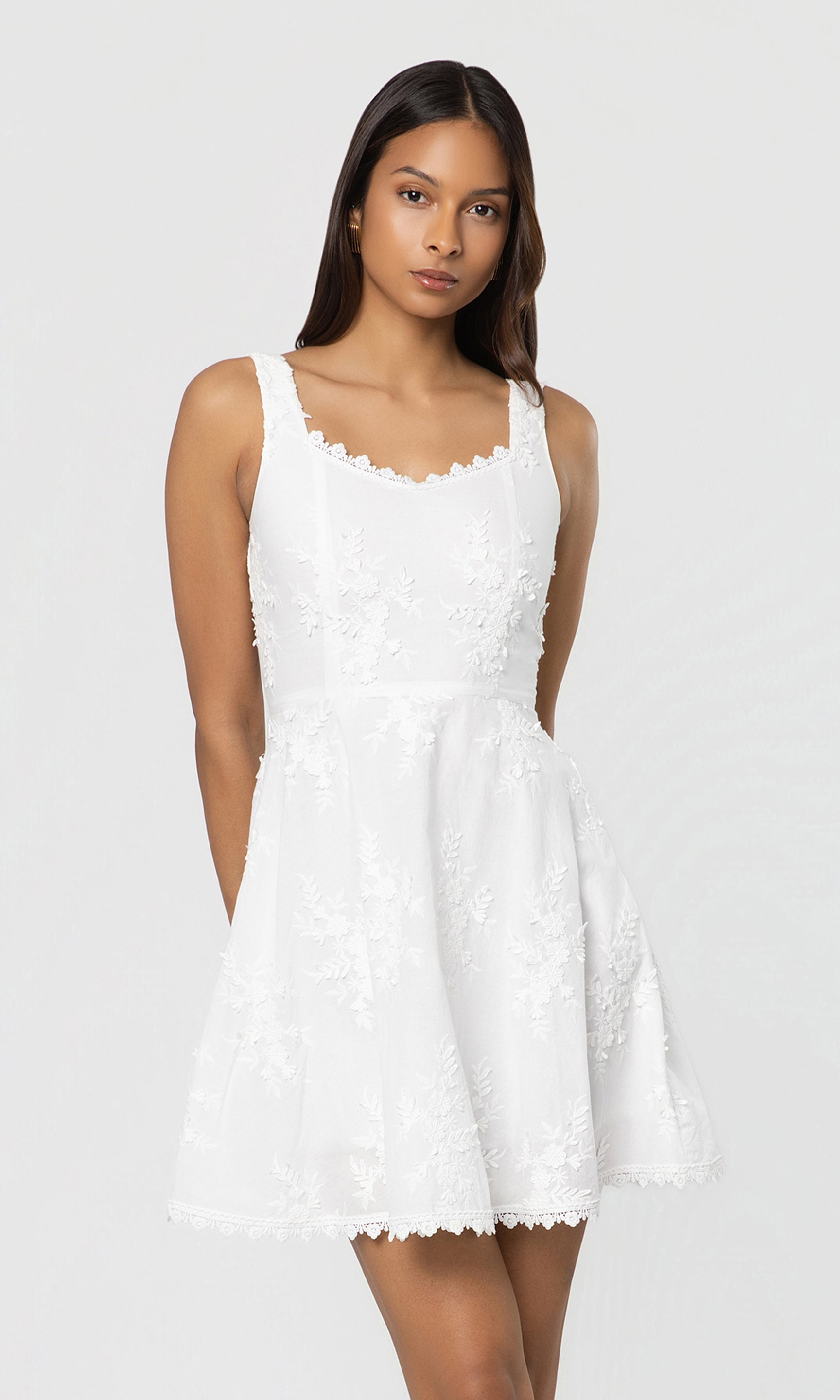 Woman wearing a white dress against a plain background