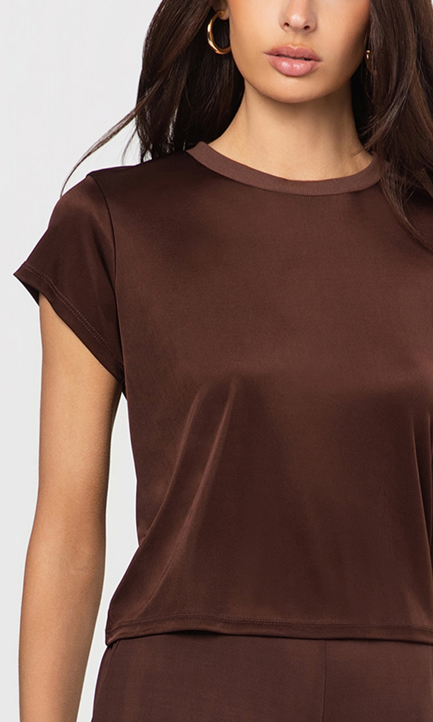 Close-up of brown t-shirt worn by a person on a white background