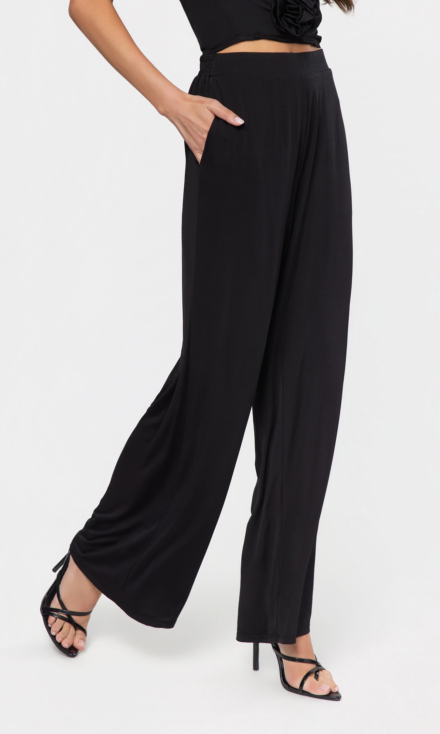 Side view of black wide-leg pants worn by a person on a white background