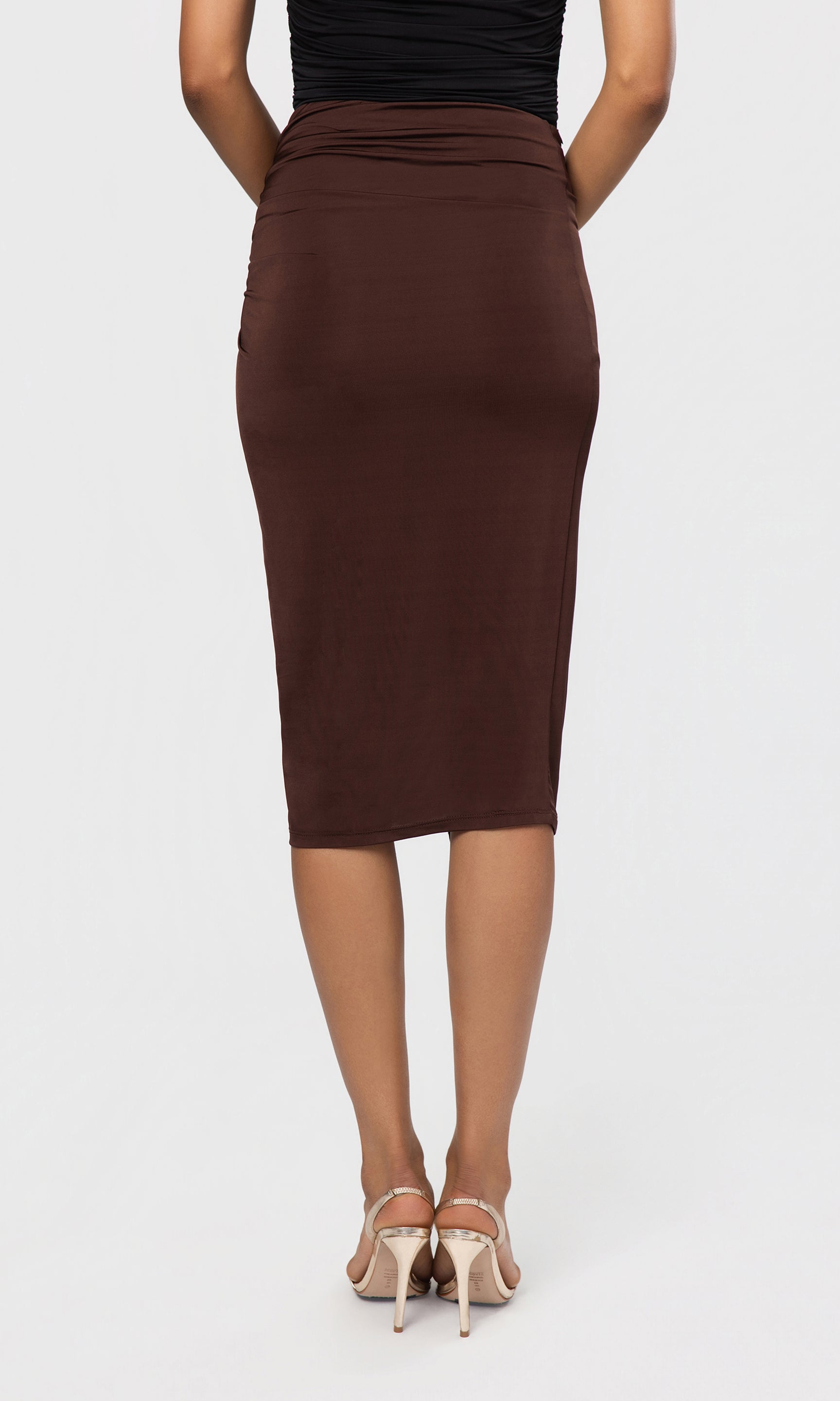Back view of brown pencil skirt worn by a person on a white background