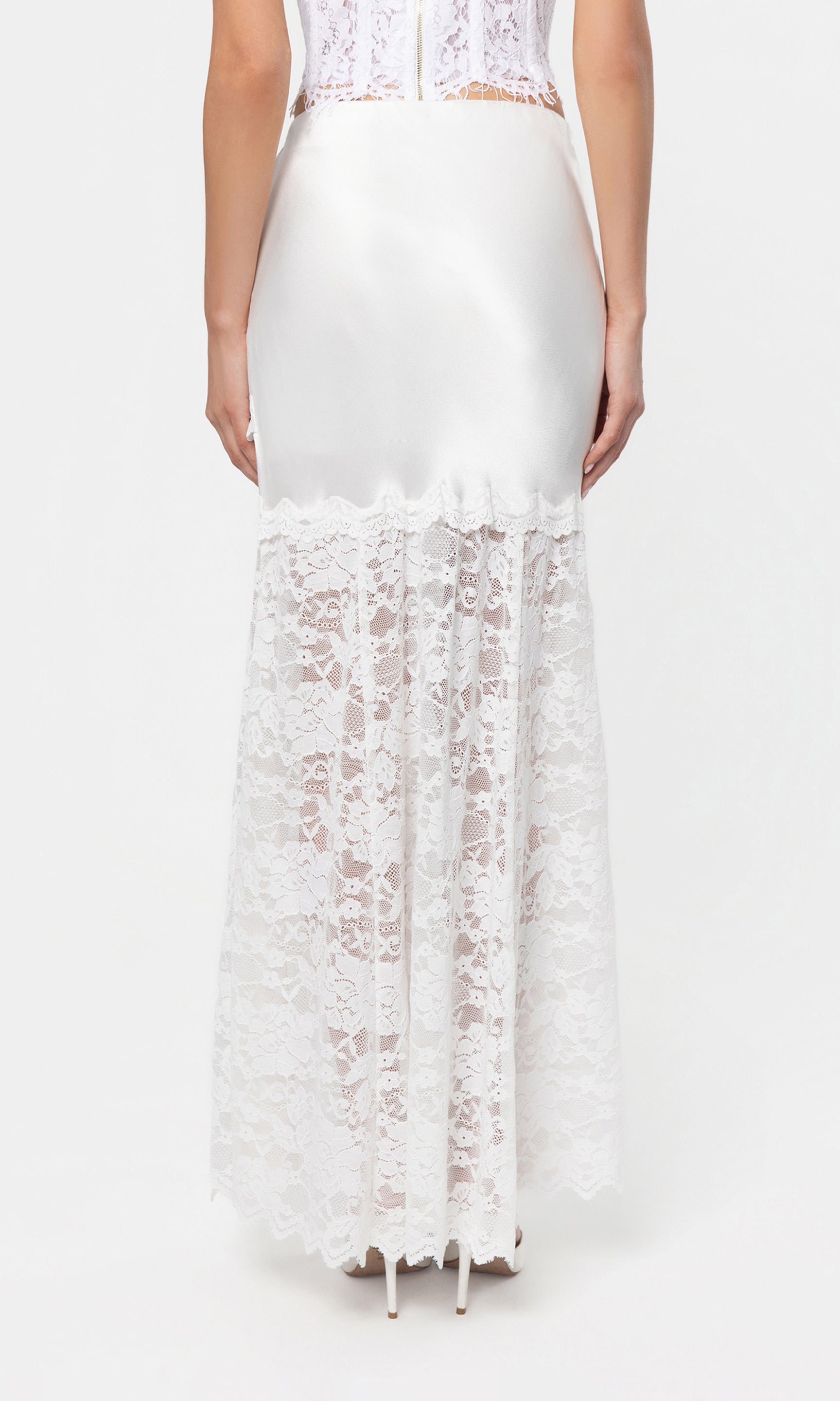 Back view of white lace skirt with a fitted bodice and flowing skirt on a white background