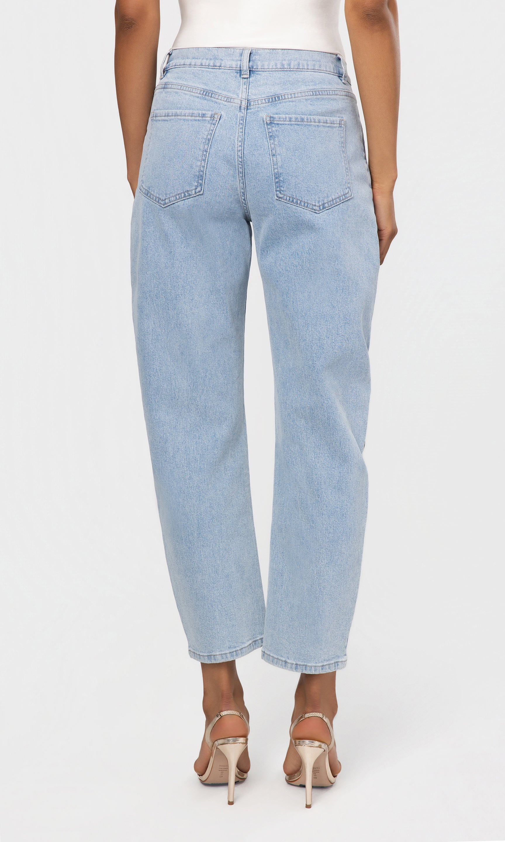 Back view of light blue jeans worn by a person on a white background