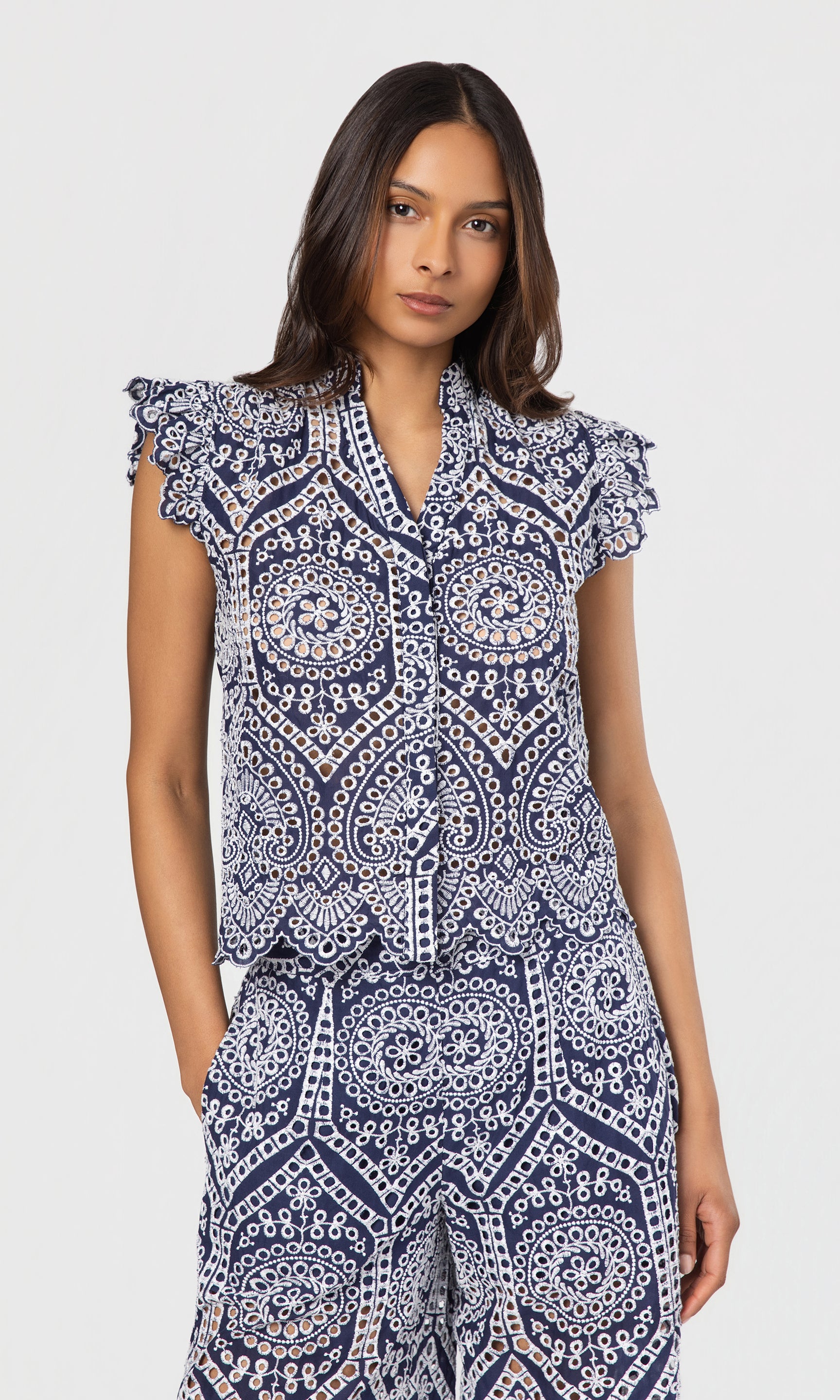 Woman wearing a blue and white patterned outfit on a white background