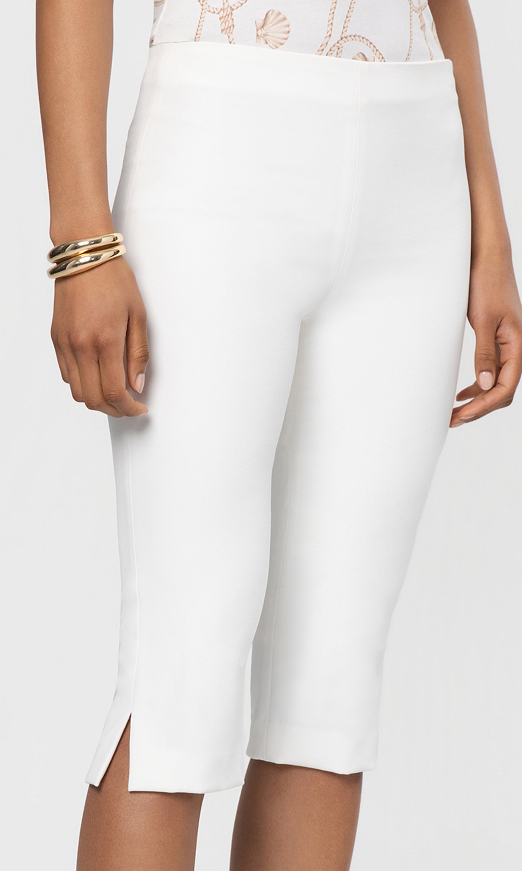 White capri pants worn by a person on a plain background