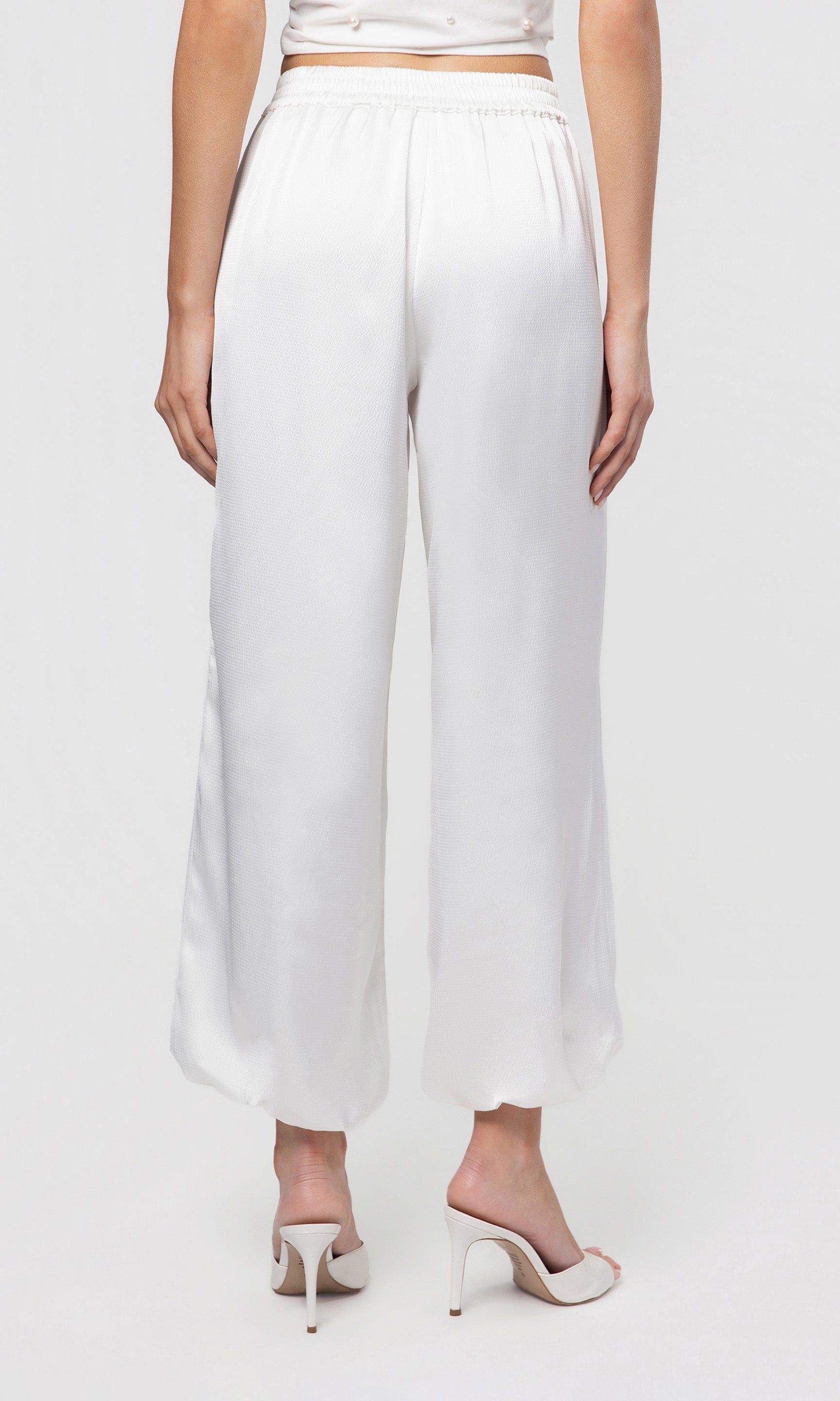 back view of white wide-leg pants worn by a person on a white background