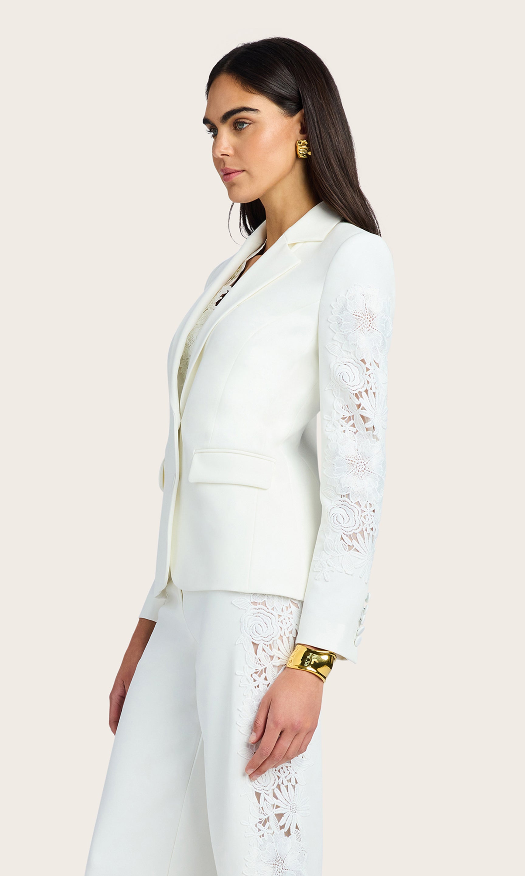 Side view of the model wearing the Venturi Lace Combo Blazer to display the profile fit and lace sleeves.