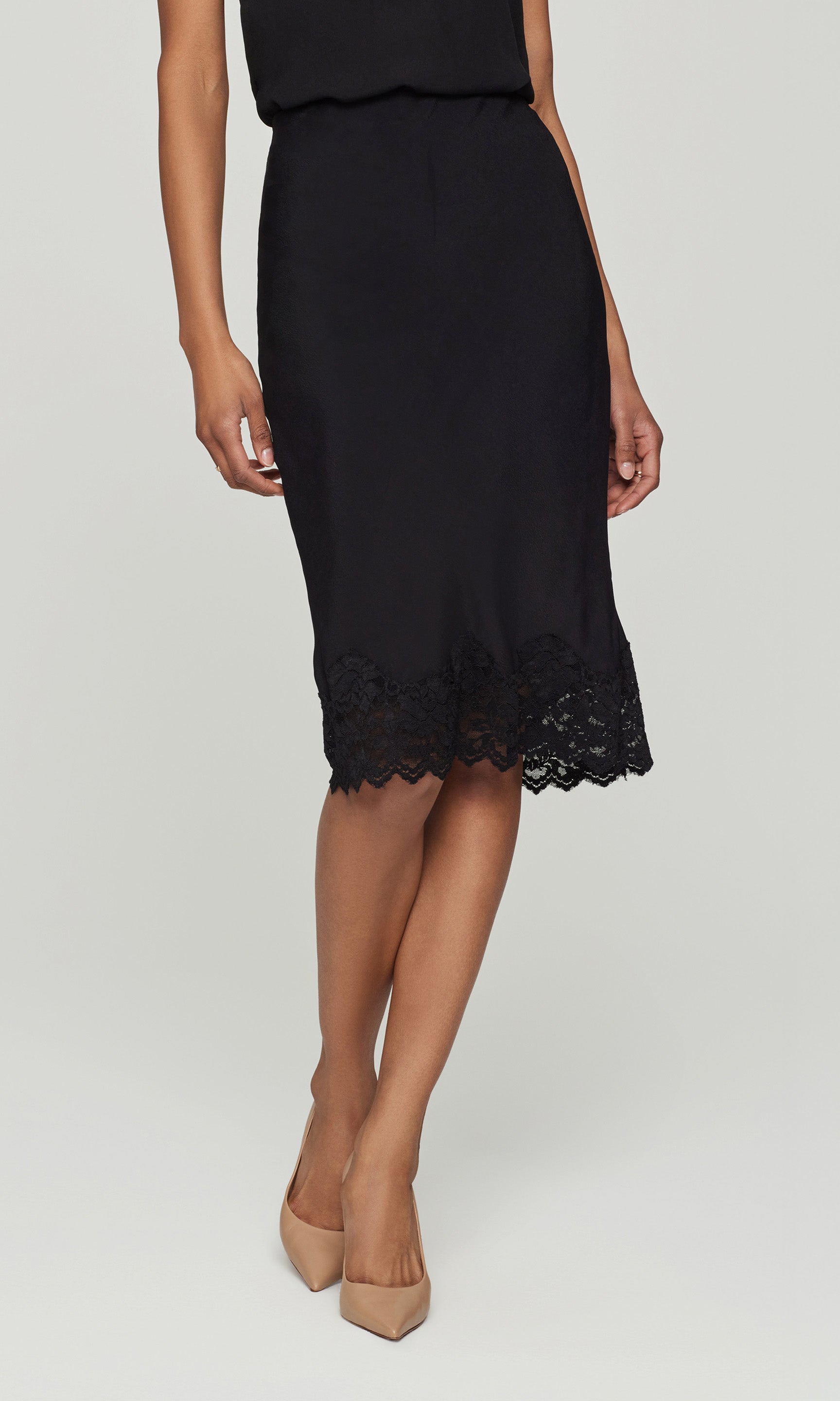 Black skirt with a lace hem worn by a person on a white background