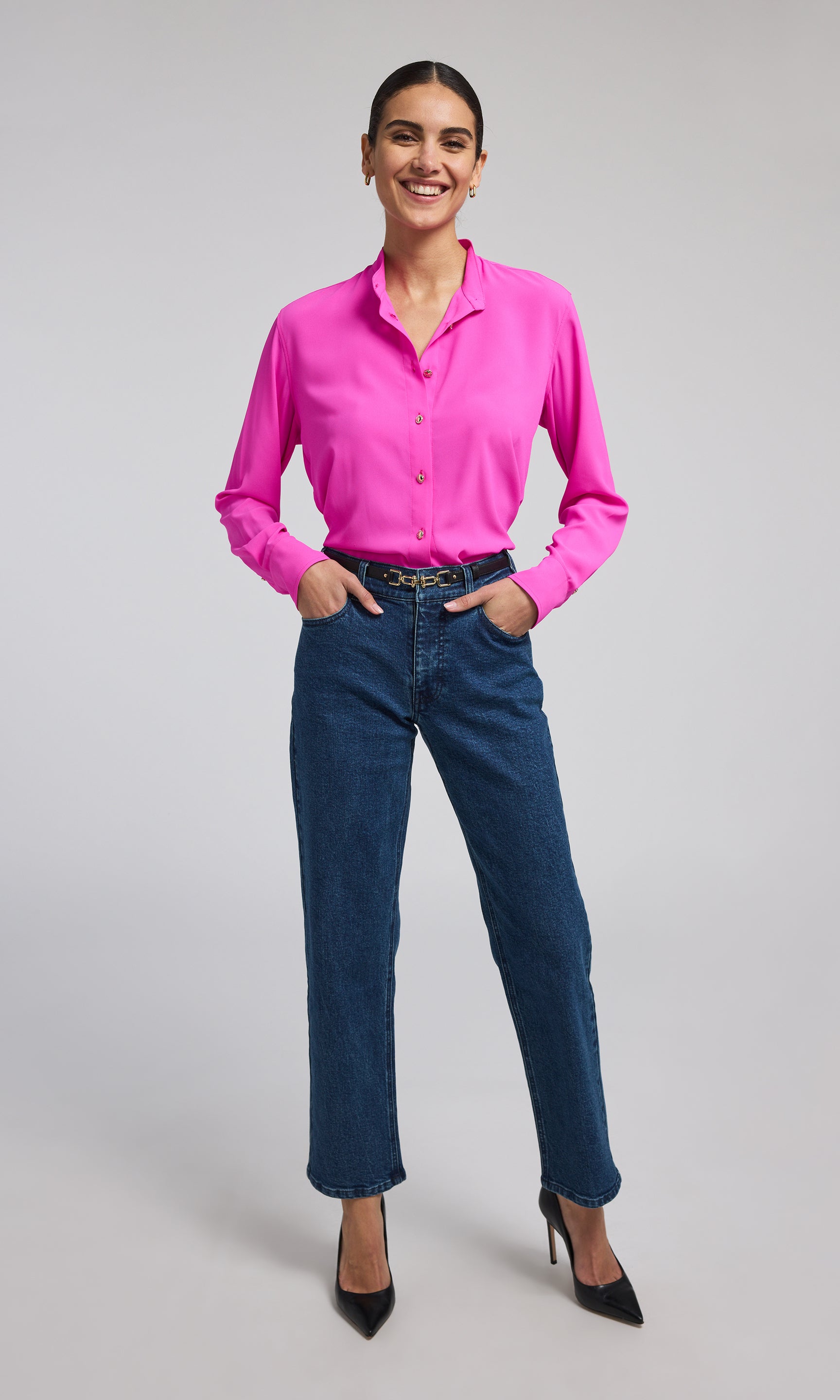 A model showcases a stylish hot pink blouse with gold buttons, highlighting its elegant design and sophisticated color.