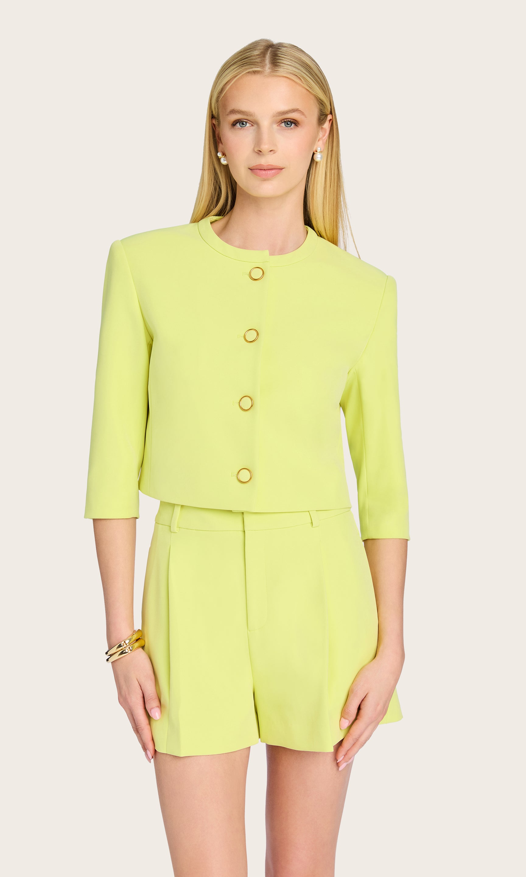 The model is seen in a clean front view wearing the Monte Crepe Jacket paired with matching shorts, displaying its modern ¾ sleeves and structured design.