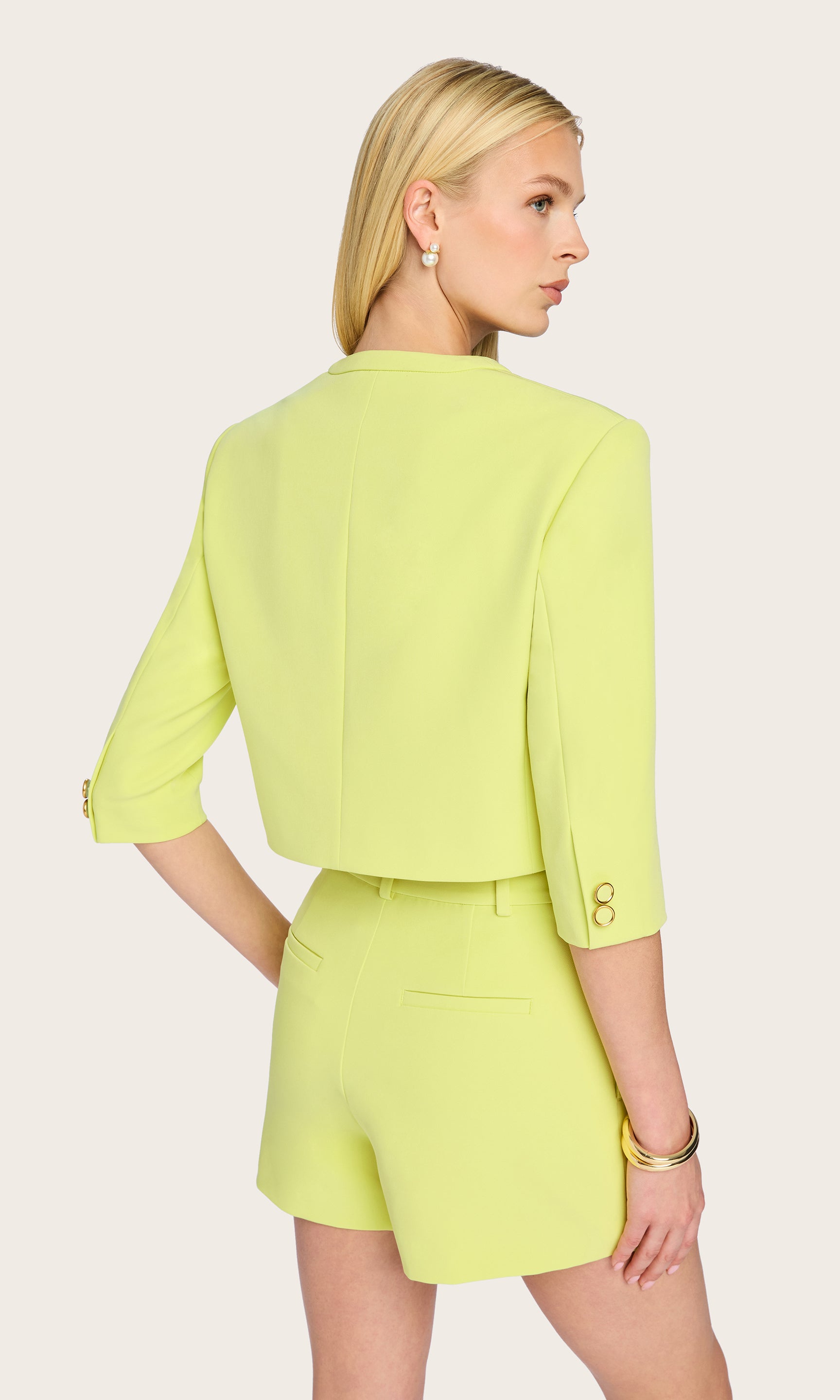 In the rear view, the model highlights the clean, streamlined silhouette and tailored seams of the Monte Crepe Jacket, drawing attention to its cropped back hem.