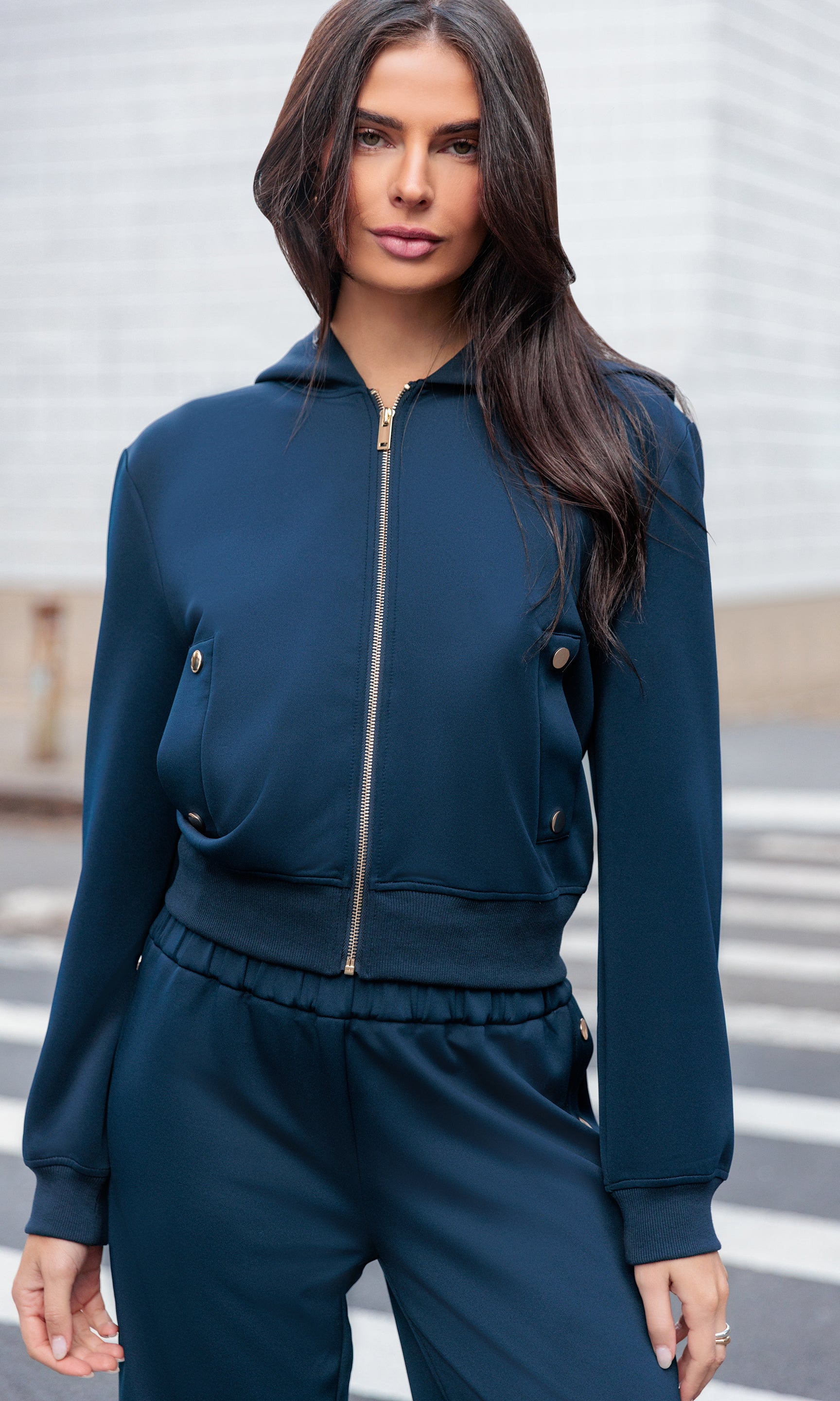 Woman wearing a blue tracksuit standing on a street.