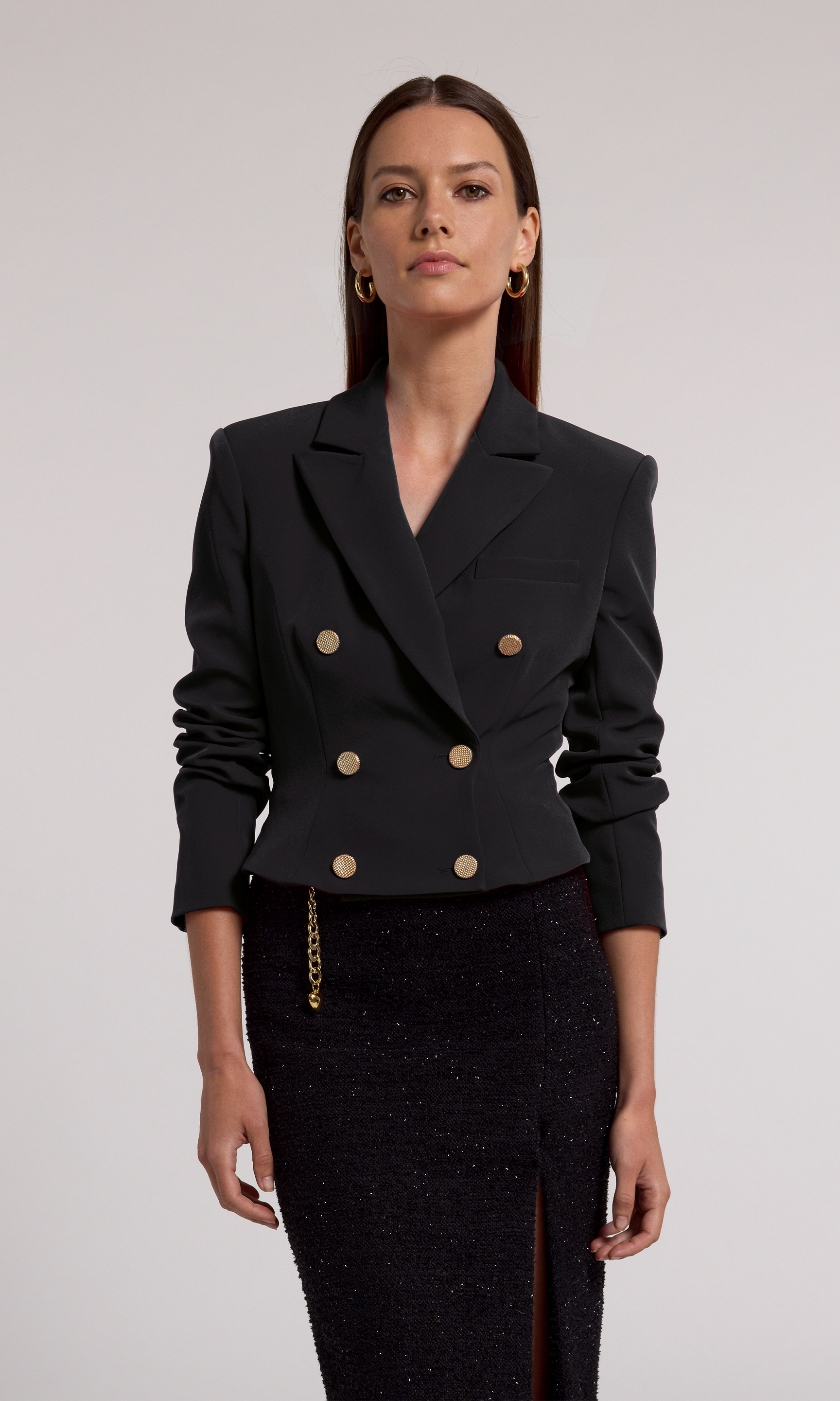 A model showcases a stylish black cropped blazer, exuding confidence and elegance in a chic fashion setting.