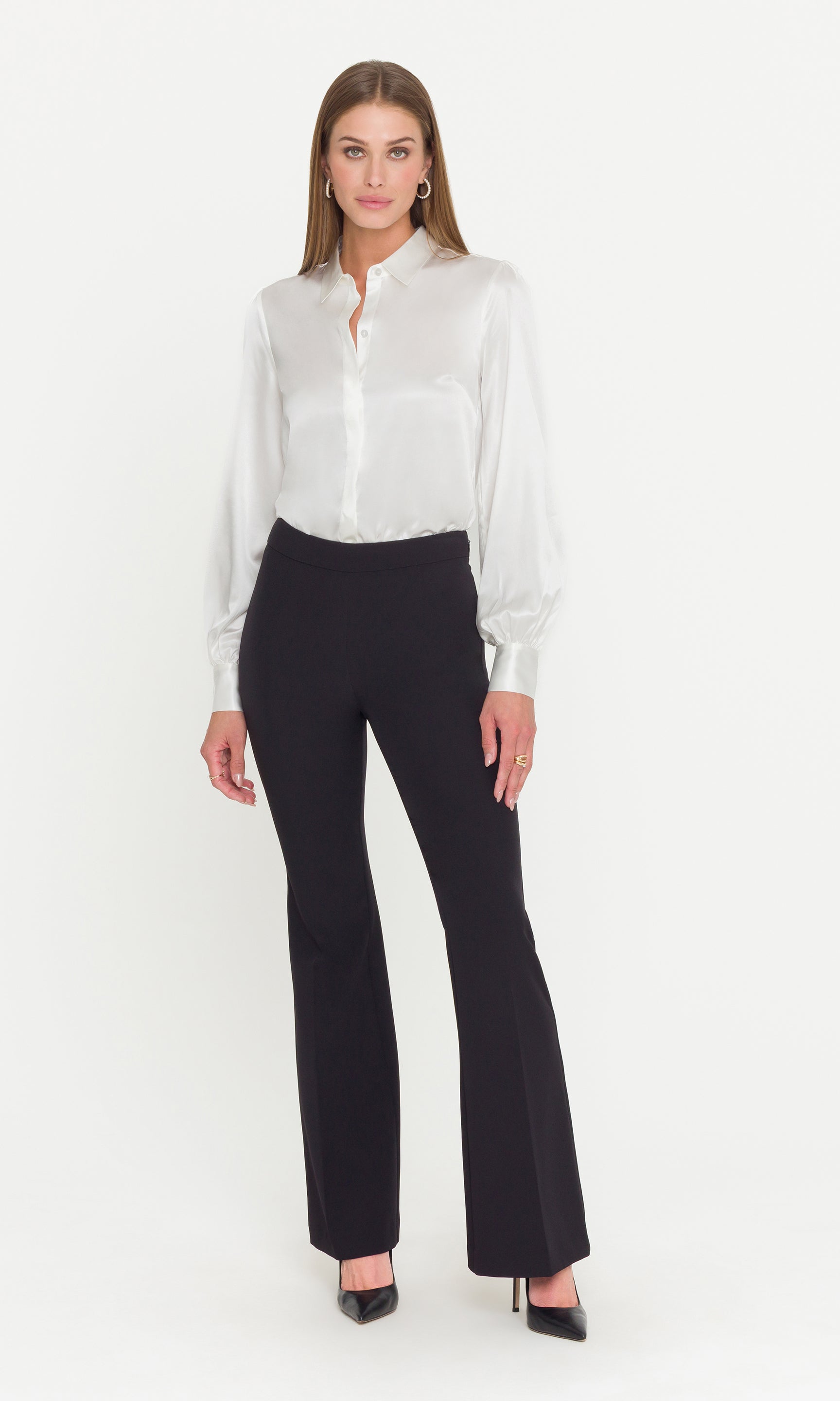 Full body image o model wearing a white blouse and black pants on a white background