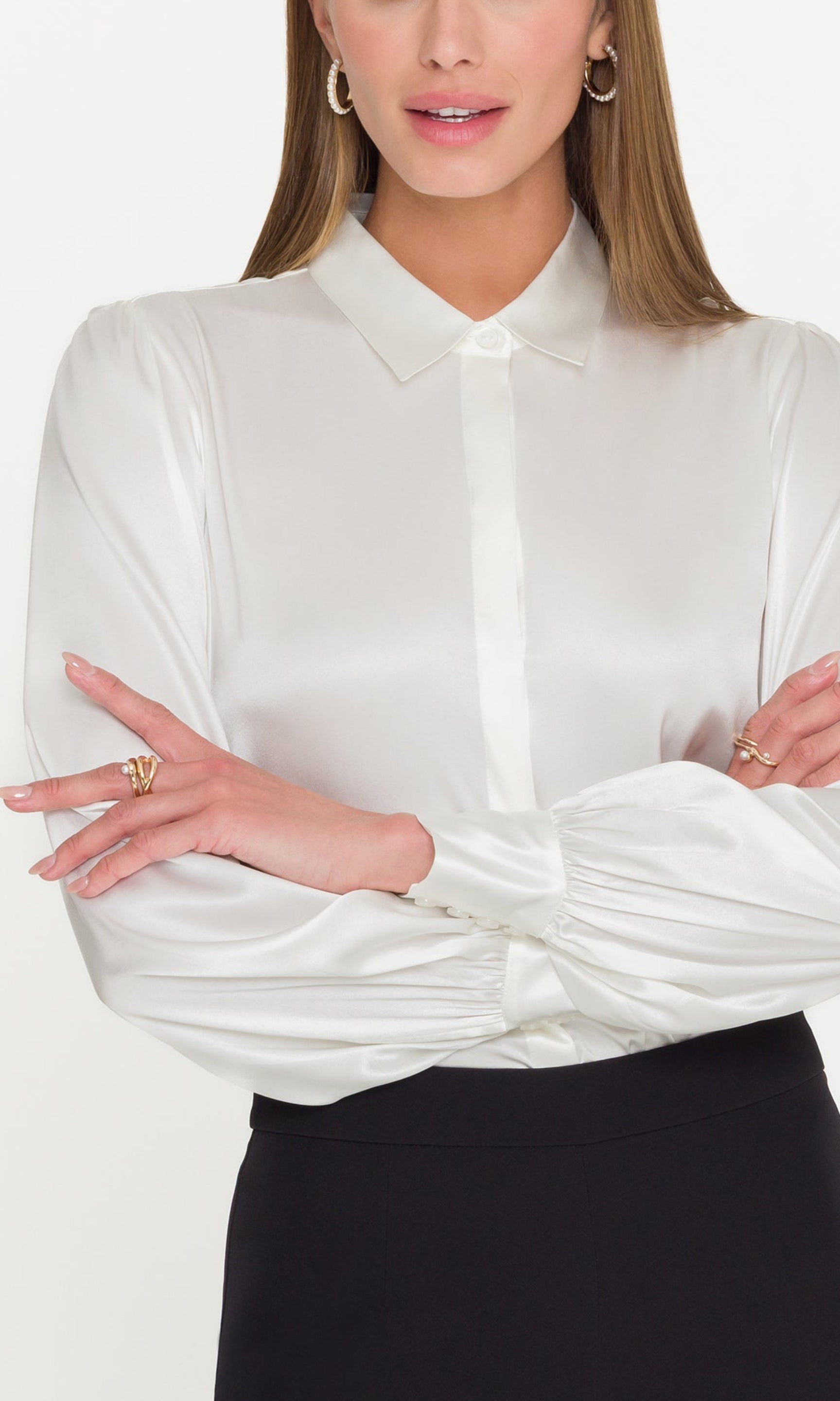 Detail image of model wearing a white blouse with her hands crossed