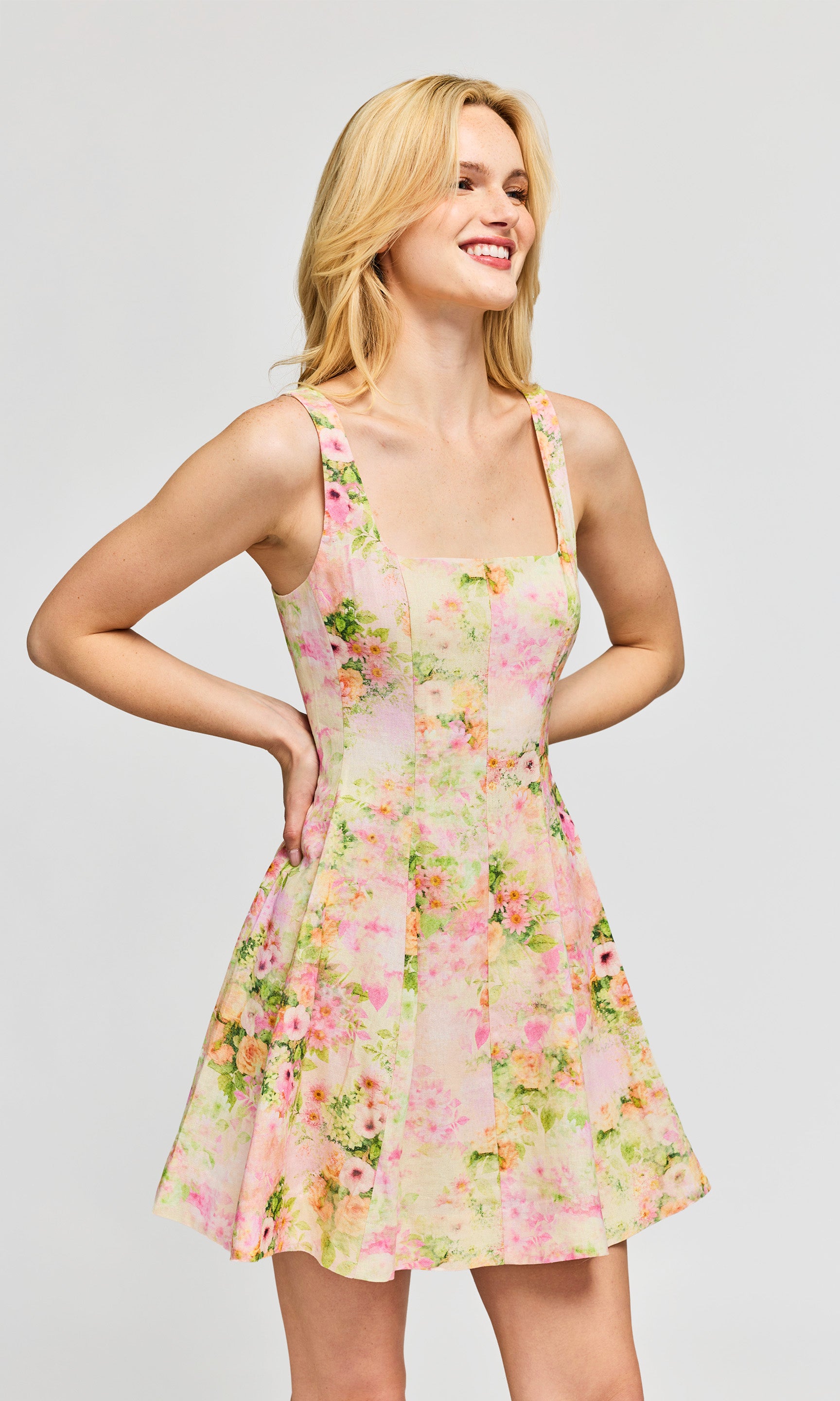 Side view of woman wearing a floral dress on a plain background